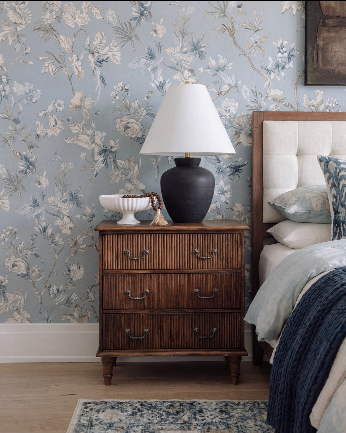 Bedroom Refresh : Shop The Look.
* Bedroom upholstered bench 
* Blue throw blanket 
* Blue traditional rug 
* Dark wood oak nightstand 
* Black vase 
* Bedroom decor 
* White decor bowl 
* Blue wall paper
* Wall art

#LTKsale #LTKhome #LTKstyletip