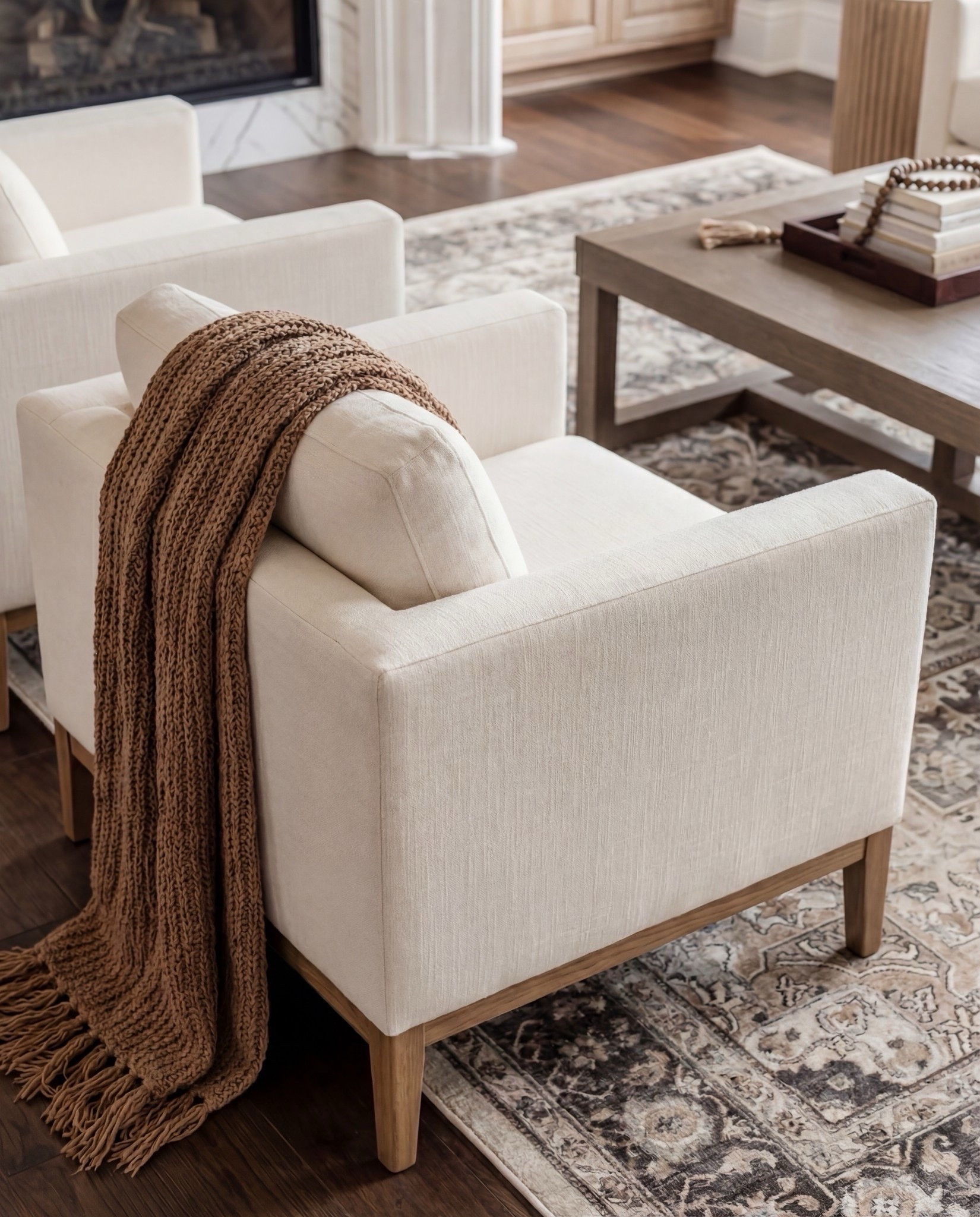 Shop the Look:
• Cream upholstered sofas
• Upholstered accent chairs (clean, modern arms)
• Marble-look fireplace décor
• Solid wood coffee table
• Neutral vintage-style area rug
• Large ceramic jug vase
• Wood + ribbed side tables
• Warm wood built-ins (or shelf styling accents)
• Throw blankets in warm caramel tones
• Neutral patterned pillows

#LTKHome #LTKSaleAlert