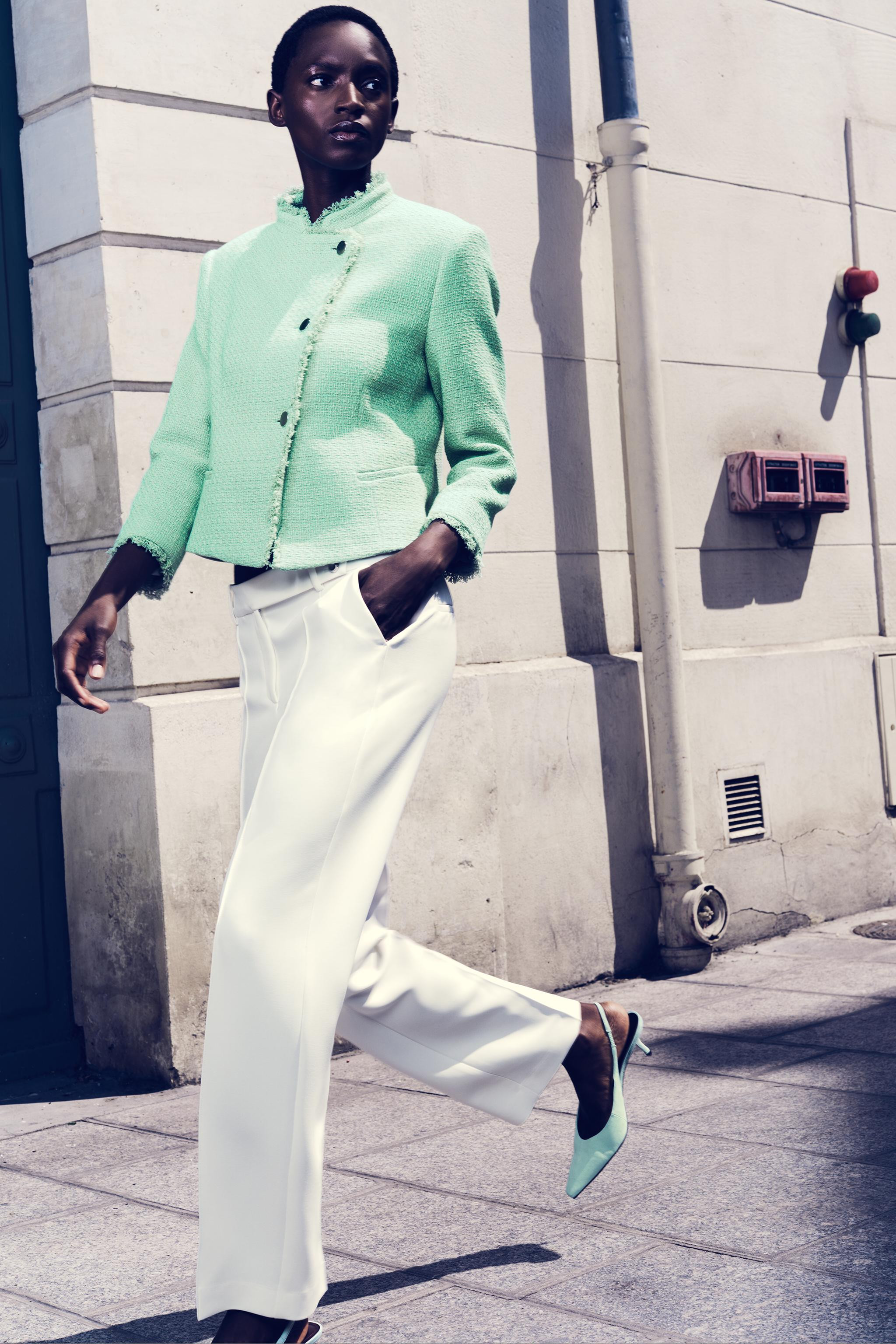 Stand collar blazer with long sleeves. Features front welt pockets, frayed trim finishes, and a d... | Zara US