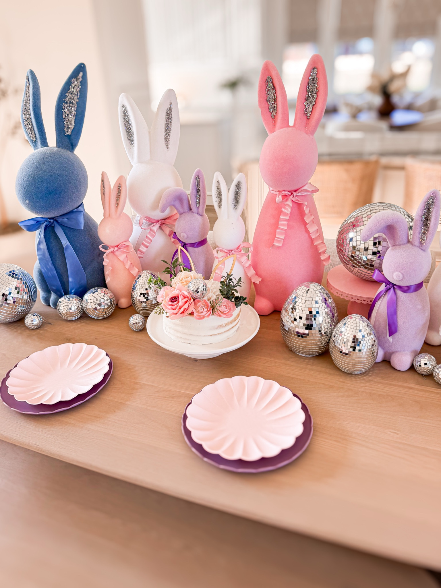 Whimsical Easter tablescape idea ✨ Flocked bunnies, disco balls, and a little sparkle—because why not?! ✨🐰 I’ve been collecting flocked bunnies for years, and this time, I gave them a little DIY glow-up with glittery ears. I lined the table with them, added some disco magic, and even found these cute disco eggs at Walmart! It’s simple, fun, and definitely a conversation starter. Would you ever do a whimsical Easter table like this? Or do you keep it more traditional? 👀 Kids Easter - Easter tablescape - flocked Easter bunnies - disco eggs - disco balls - Easter party 

#LTKSeasonal #LTKHome #LTKPetite