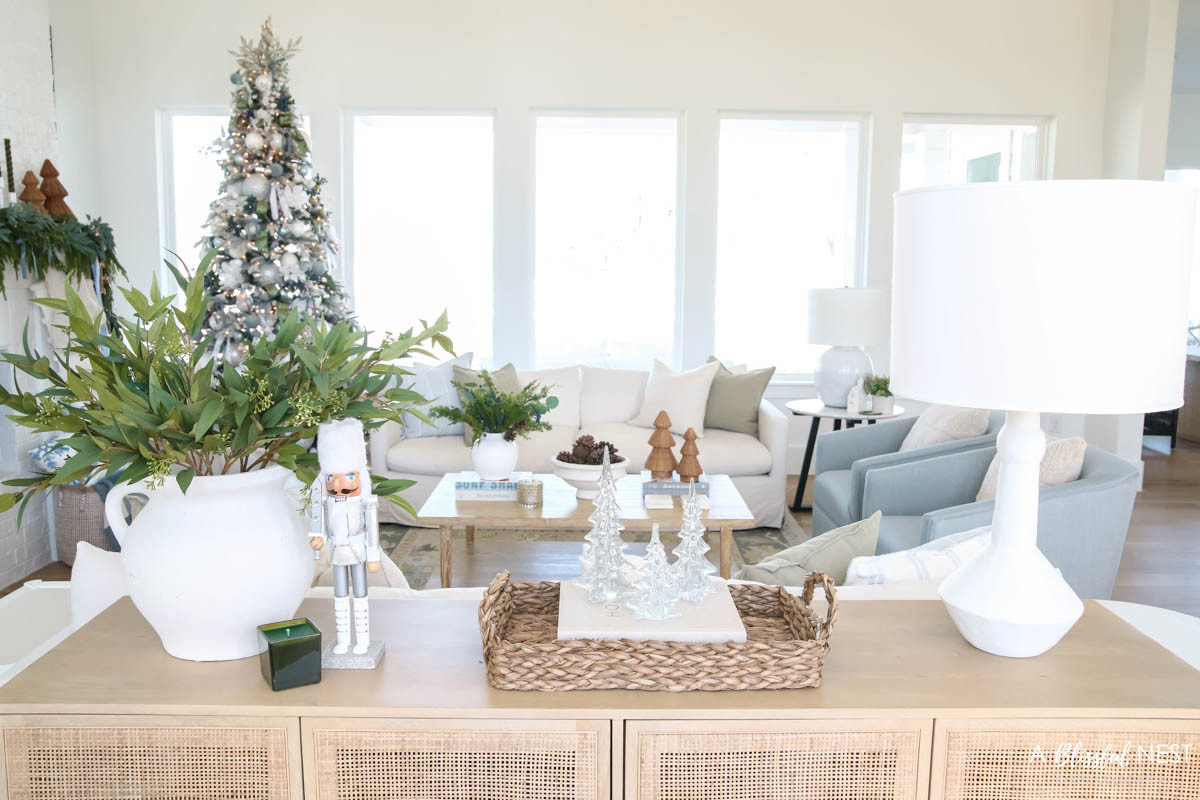 This space feels so calm with layered textures and gentle Christmas tones. Tap to shop the look.
illuminated LED Christmas tree, scented candle, rattan tray, silver Christmas soldier decor, natural cane mango wood sideboard, greenery stems, natural pine cones, cream textured pillow, blue accent chair. sage green pillow, cream sofa, faux blueberry stems, rattan wicker Christmas tree cone 

 #LTKHoliday #LTKSeasonal #LTKHome