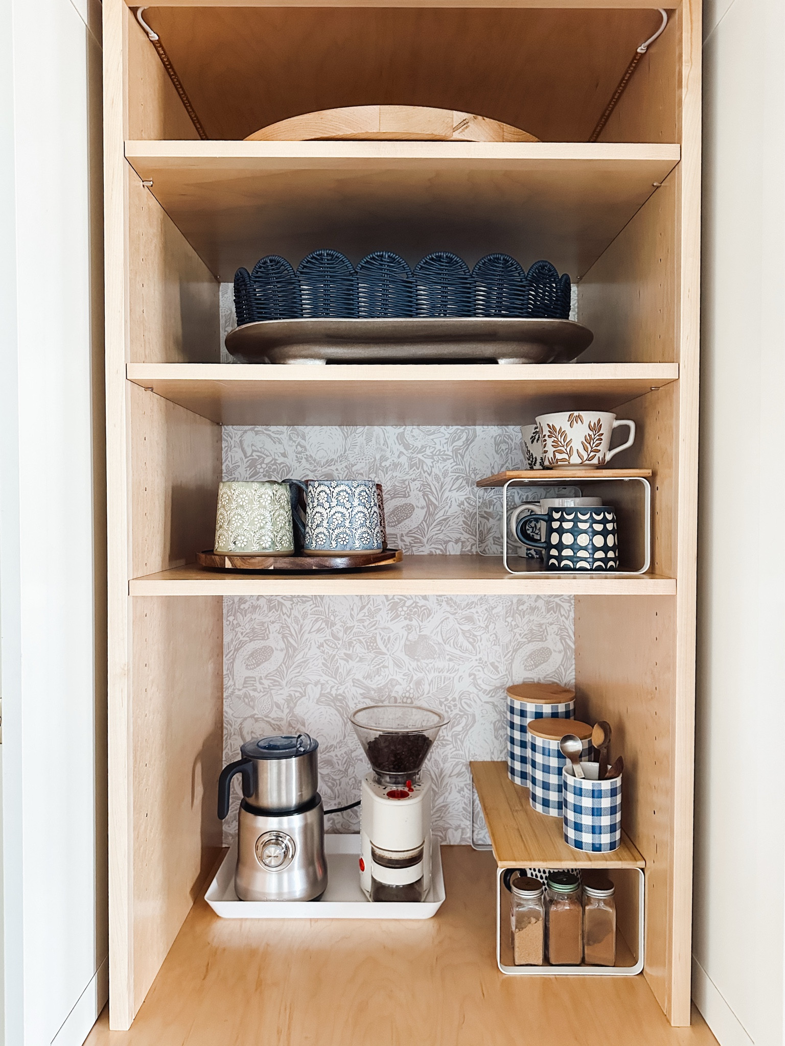 My coffee cabinet. Shelf risers, removable bunny patterned wallpaper, wood and white tiered stands, mugs, tray, grinder, milk steamer, stand for Berkey water filter, wood lazy susan turntables, checkered blue + white canisters w/ wood lids


#LTKSeasonal #LTKStyleTip #LTKHome