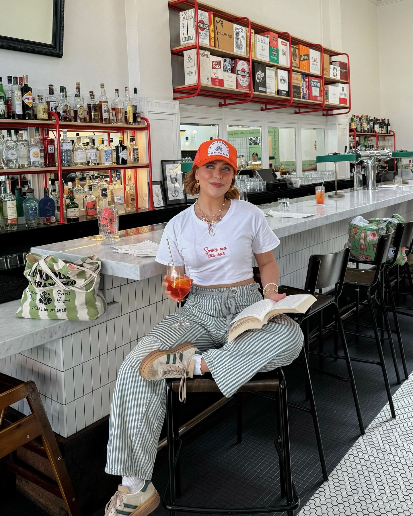 A good gossip sesh & an Aperol is exactly what brat summer prescribed 🍹

Spritz out ti*s out 🫶 @polychromegoods 

#aperoltime #truckerhats #charmnecklace #adidasgazelle #pinterestoutfit #bratsummer