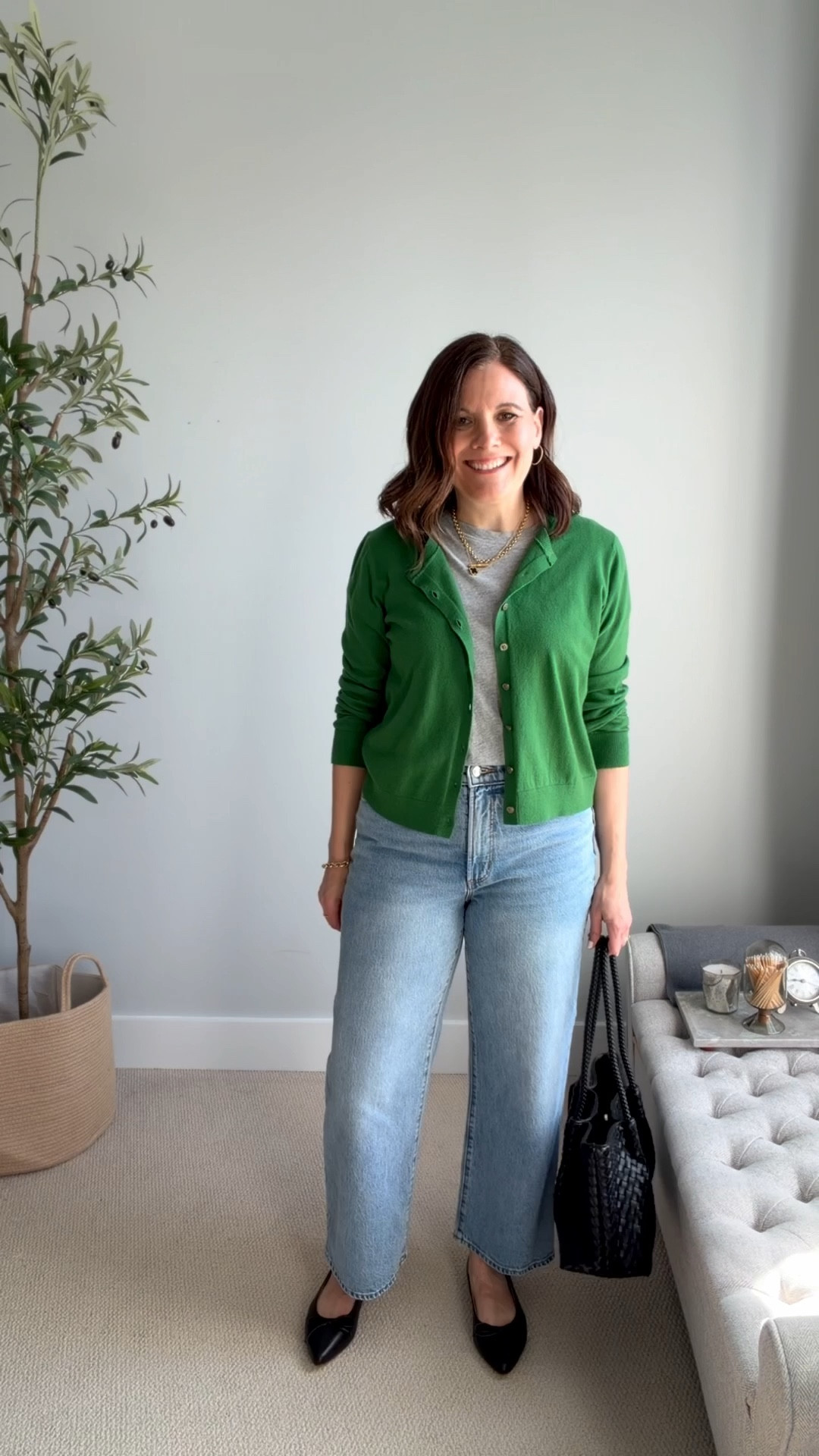 We often default to a white tee and jeans, but a light gray tee is a fresh alternative. It’s a simple styling hack that makes your outfits feel a little more unexpected without changing much else. Here I’m pairing a light gray tee with LOFT medium-wash wide-leg cropped jeans (size down) and this Kelly green cardigan (I wear a medium  when I wear it buttoned like a top or large for layering). Pops of black ground the look with pointed-toe black ballet flats and a black woven tote bag.
