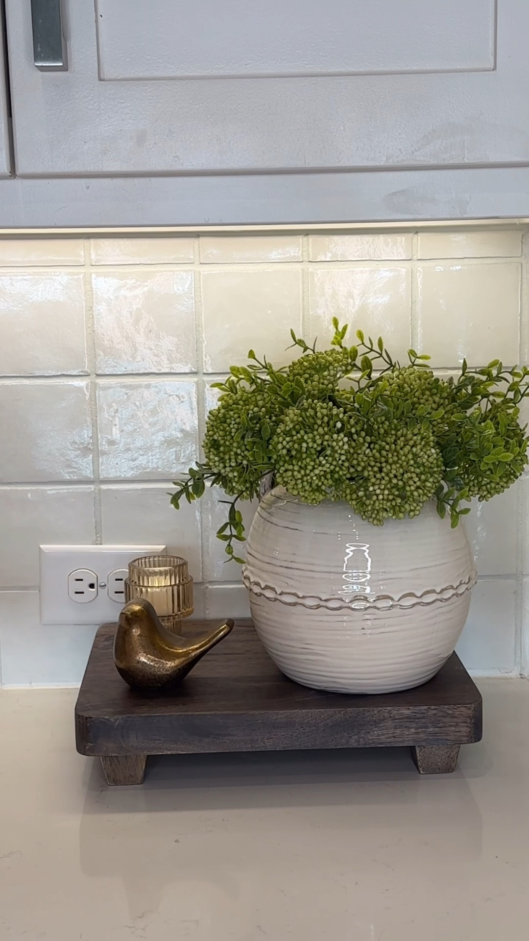 Kitchen styling 

Less really is more when it comes to a beautiful, elevated kitchen counter. 
Start with a simple riser to create height and dimension, then layer in just a few intentional pieces—a ceramic pot with fresh sedum for a touch of life, a brass bird for warmth and character, and a crystal candle holder to reflect light and add that subtle hint of elegance.
It’s proof that you don’t need a lot to make a space feel styled… just the right pieces placed with purpose 