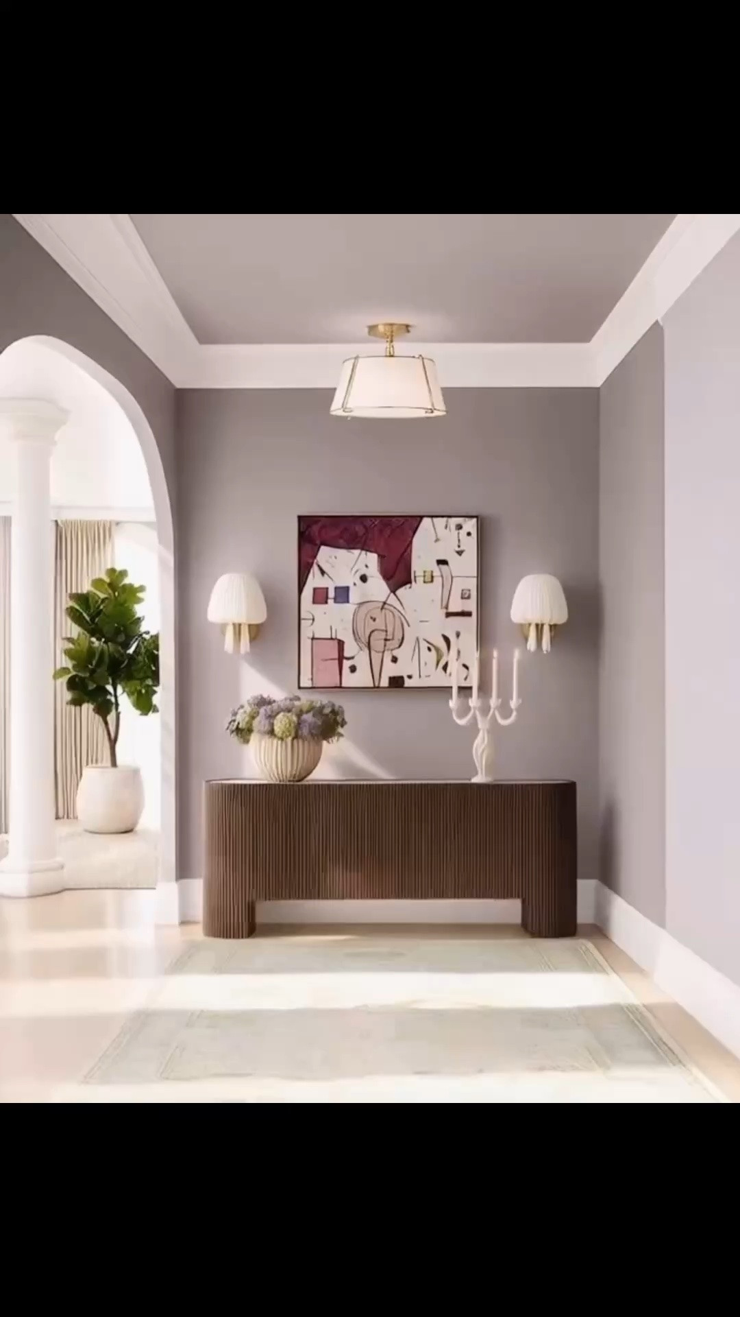 Transitioning into fall starts right at the entrance—the first space that welcomes you home. 🍂

I love the mix of soft lavender, rich mocha brown, and muted green in this entryway. It feels warm and inviting for fall, while still looking refreshing, playful, and sophisticated.

The Flore Sideboard from Arhaus anchors the space beautifully. Its softly curved silhouette, solid oak reeded detailing, and rich mocha finish bring so much warmth and texture. The Calacatta Viola marble top adds an elevated, timeless contrast, while the soft-close doors and adjustable interior shelving make it just as functional as it is beautiful.

I also love the playful abstract artwork and its expressive mix of plum, blush, cream, and mocha tones. The colors connect so naturally with the lavender walls and deep brown sideboard, making the entire entrance feel thoughtfully layered.

The fabric wall sconces from Lulu and Georgia are especially unique—the softly gathered ivory shades and antique brass details add a sculptural, tactile quality that feels elegant and unexpected.

The semi-flush ceiling light from Rejuvenation brings another beautiful layer to the space. I love Rejuvenation for its exceptional quality and solid-brass craftsmanship. This fixture feels clean and modern, while its refined proportions and warm brass details give it a timeless, sophisticated presence.

A hand-knotted green rug completes the palette with a soft, natural layer. It’s a warm welcome home—inviting, collected, and refreshed for the season ahead.#LTKStyle #FallHome #FallRefresh #EntrywayDesign #EntrywayDecor #Arhaus #FloreSideboard #Sideboard #Credenza #LuluAndGeorgia #Rejuvenation #SemiFlushMount #CeilingLight #WallSconce #LightingDesign #AbstractArt #WallArt #AreaRug #HandKnottedRug #InteriorDesign #ModernClassic #TransitionalStyle

#LTKHome #LTKdayinmylife #LTKHome #LTKSaleAlert