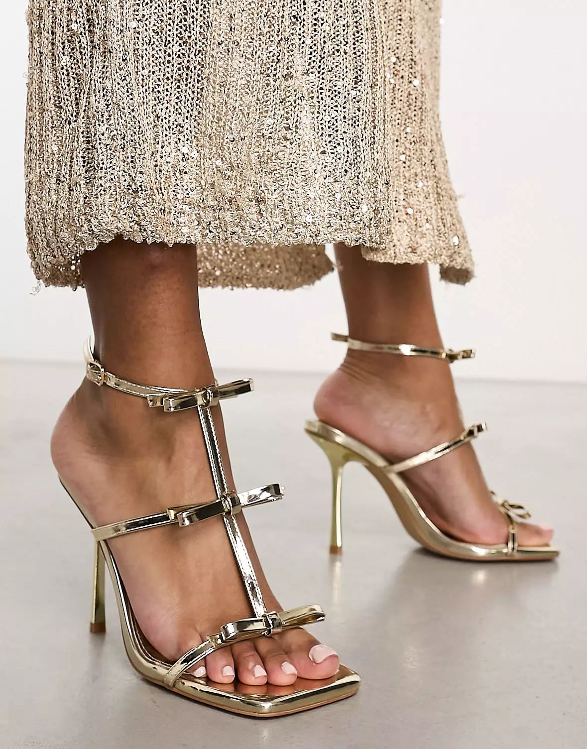 Simmi London Exclusive Riva high heeled sandals with bow details in mirrrored gold | ASOS (Global)