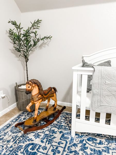 Neutral boy nursery decor. 

White target crib, faux olive tree, nearly natural, grey baby quilt, blue square rug, vintage rocking horse, baby boy room. 

#LTKkids #LTKhome #LTKbaby