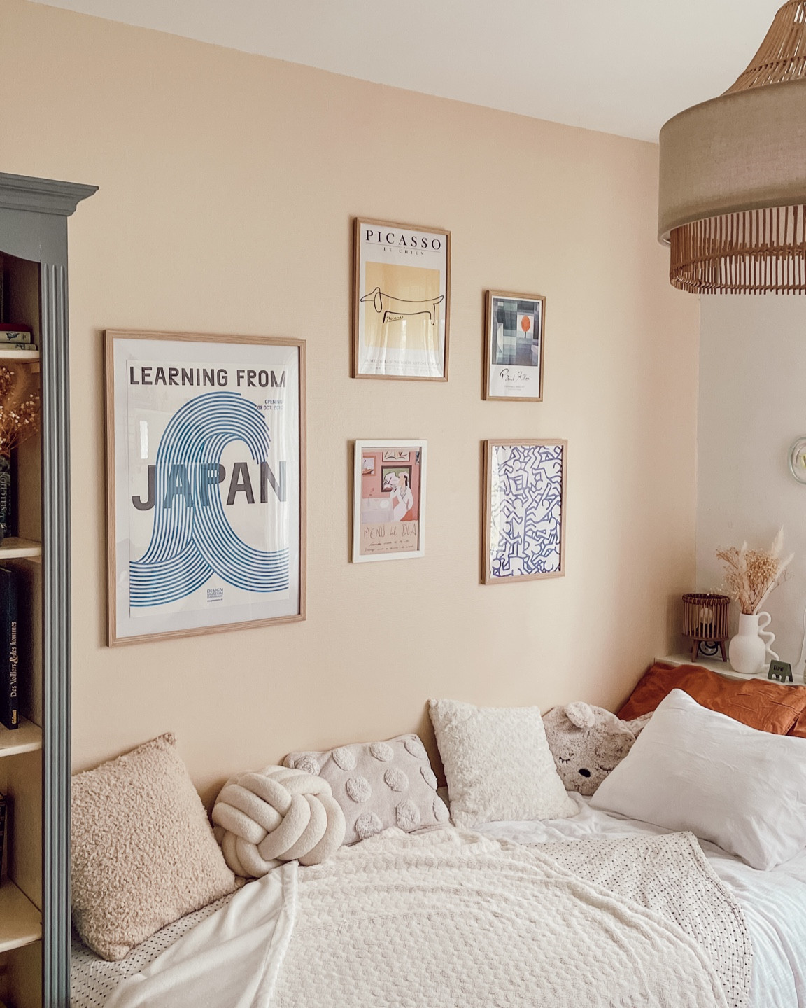 Mur de cadres sur un mur beige dans une chambre cosy avec des couleurs douces et neutres. 

#LTKhome