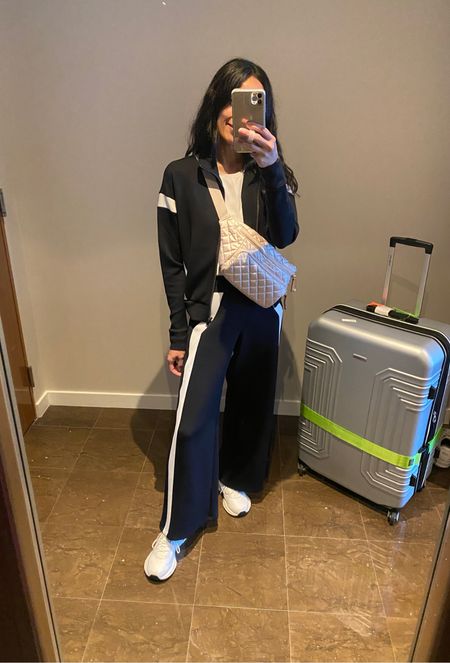 Travel outfit. 
Track jacket looks cute with jeans too. True to size. 
Wide leg track pants. True to size for me and I’m in Petite length at 5’4. 
Sneakers are good for travel. 
Sling bag  Belt bag. 
Luggage. Suitcase. 
Luggage strap. 

#LTKstyletip #LTKover40 #LTKtravel