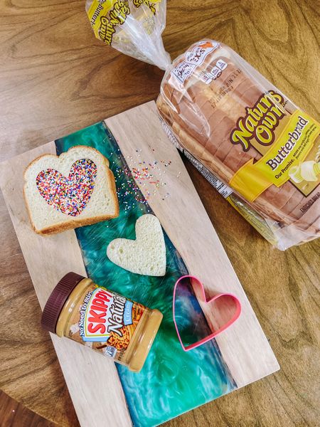 #AD I am having so much fun reimagining PB&J sandwiches for Cami’s school lunch this year! As I mentioned before, the girl could eat a PB& J everyday twice a day if I let her!

At @Target I found my favorite bread, @naturesownbread butter bread! I also have been loving the natural creamy peanut butter from @skippybrand. Add a few sprinkles and this was the inspo for Cami’s latest elevated sandwich!

I used a heart cookie cutter and cut the center out of one slice of bread. On the other slice I spread the peanut butter. I placed the open piece of bread with the heart shape on top of the peanut butter slice and then went to town filling in the heart shape with sprinkles. How fun is that! Once the sprinkles are in place, gently press them down so that they stick the peanut butter! Easy and really fun to make!

You can find everything you need for your next PB&J linked in my LTK shop so that you can shop directly from there!
#Target, #TargetPartner, #brunch, #peanutbutter, #pb, #tasty, #easysnack, and #schoolsnack

#LTKFind #LTKfamily #LTKBacktoSchool