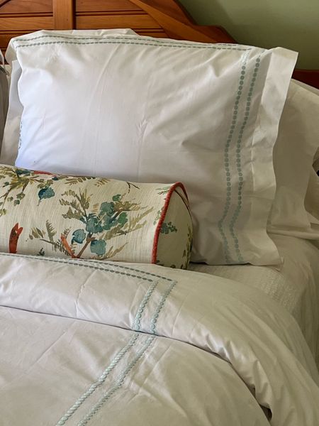 Crisp white bedding with a touch of color in an embroidered border  
