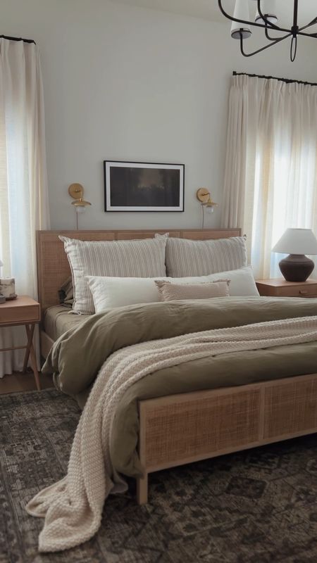 Primary bedroom, wood and cane bed, olive linens, Quince, moody wall art, wall sconce, pleated drapes, curtains, nightstand, table lamp, bed pillows, lumbar, interior decor

#LTKhome #LTKstyletip