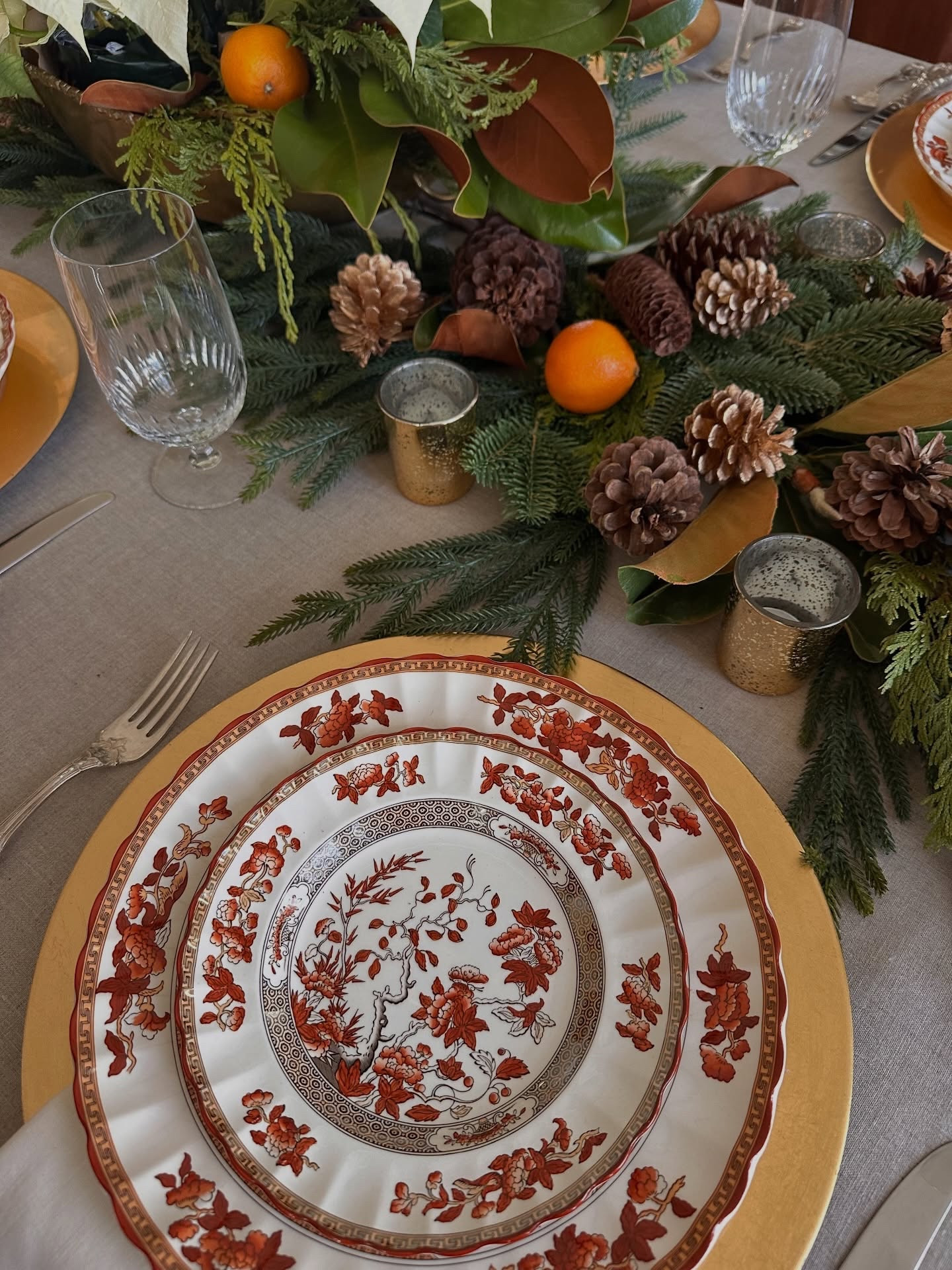 Christmas tablescapes don’t have to include red and green. I loved using my grandmother‘s  Indian Tree with fresh and faux greens, pinecones, and clementines.  Burgundy silver is always a classic, and I love that I will pass it down to my daughters one day.

The beautiful linen tablecloth is the perfect neutral background for the stunning china. An easy white poinsettia centerpiece in a beautiful brass vessel gifted to me by my mom completes the table.  It’s always special using family heirlooms!

#LTKHome #LTKHoliday #LTKdayinmylife
