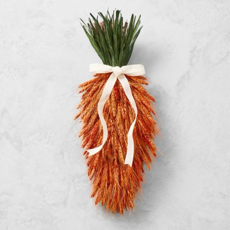 This clever carrot wreath is handcrafted by skilled artisans using dried wheat and corn husks. Perfect for spring celebrations, it hangs easily from doors and walls and is finished with a white ribbon. Rich with natural texture and color enhanced for vivid beauty, it's a distinctive design you'll enjoy all season.

#LTKhome #LTKSeasonal #LTKfindsunder100