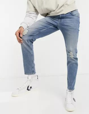 ASOS DESIGN stretch tapered jeans in mid wash with knee rips | ASOS (Global)