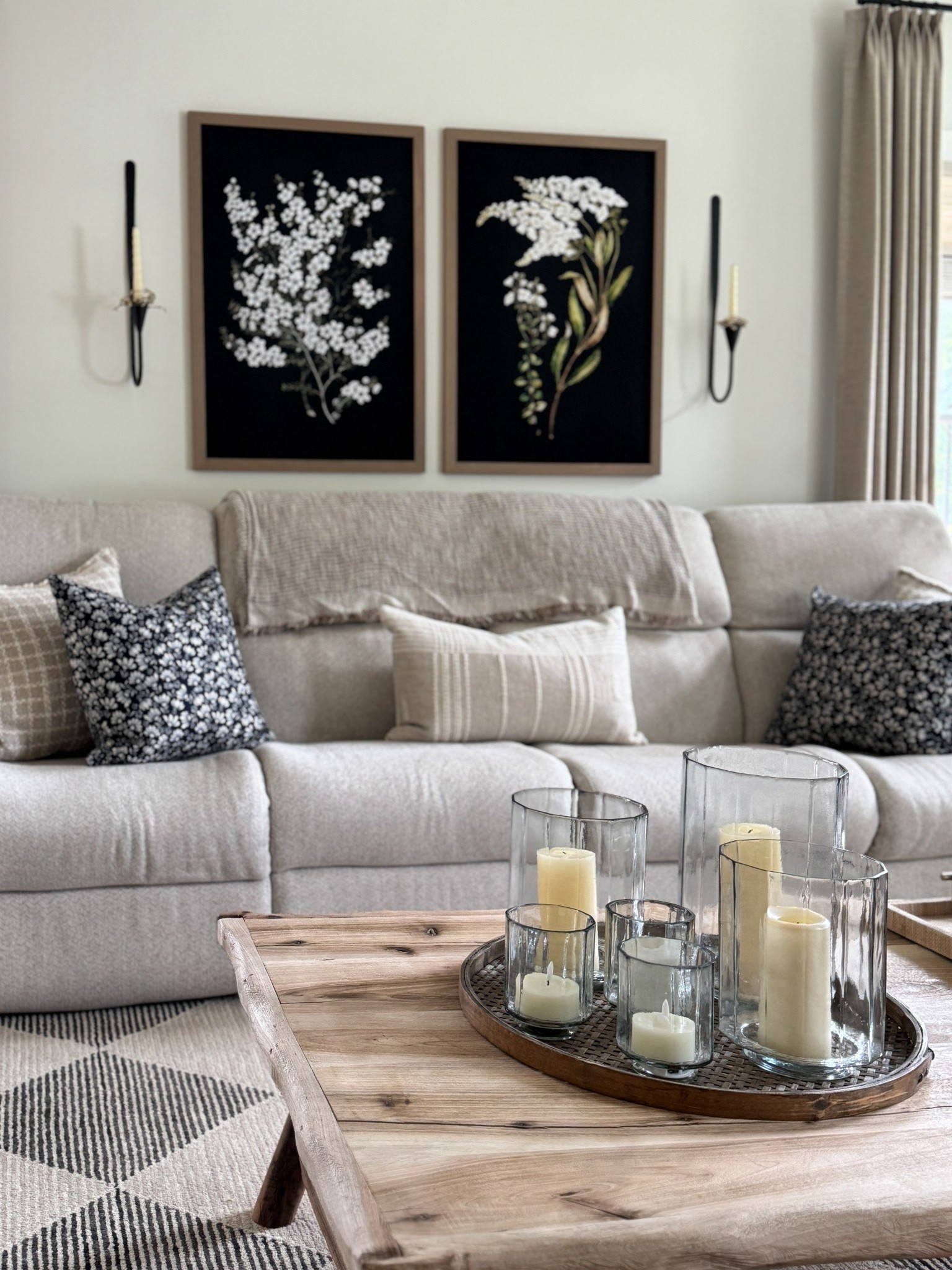 Sharing some of my black/warm neutral decor and furniture. Two large floral prints on black background. Antiqued bronze metal wall sconces. Cream and black floral pillow throws. Textured glass hurricane candle holders in three sizes. Charcoal and neutral area rug. Also sharing my tall black bookcase, accent chairs and solid wood black dining chairs. 

#LTKHome