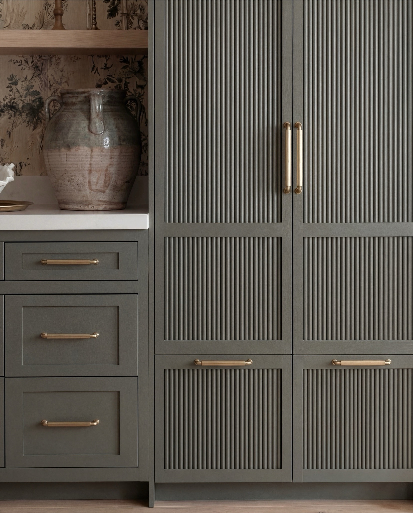 Shop the Look:
• Muted green paneled cabinetry
• Brass cabinet pulls + drawer handles
• Fluted panel tall cabinets
• Glass-front upper cabinets
• Floral wallpaper (neutral botanical pattern)
• Brass wall sconce with white shade
• Light wood floating shelf
• White espresso machine
• Built-in beverage fridge
• Built-in wine fridge
• Clear wine glasses + stemware set
• Stacked ceramic plates + bowls
• Neutral ceramic mugs
• Sculptural ceramic bowl (organic shape)
• Large ceramic vase (earthy tones)
• Light wood flooring
• Vintage-style runner rug (soft neutral pattern)

#LTKSaleAlert #LTKHome