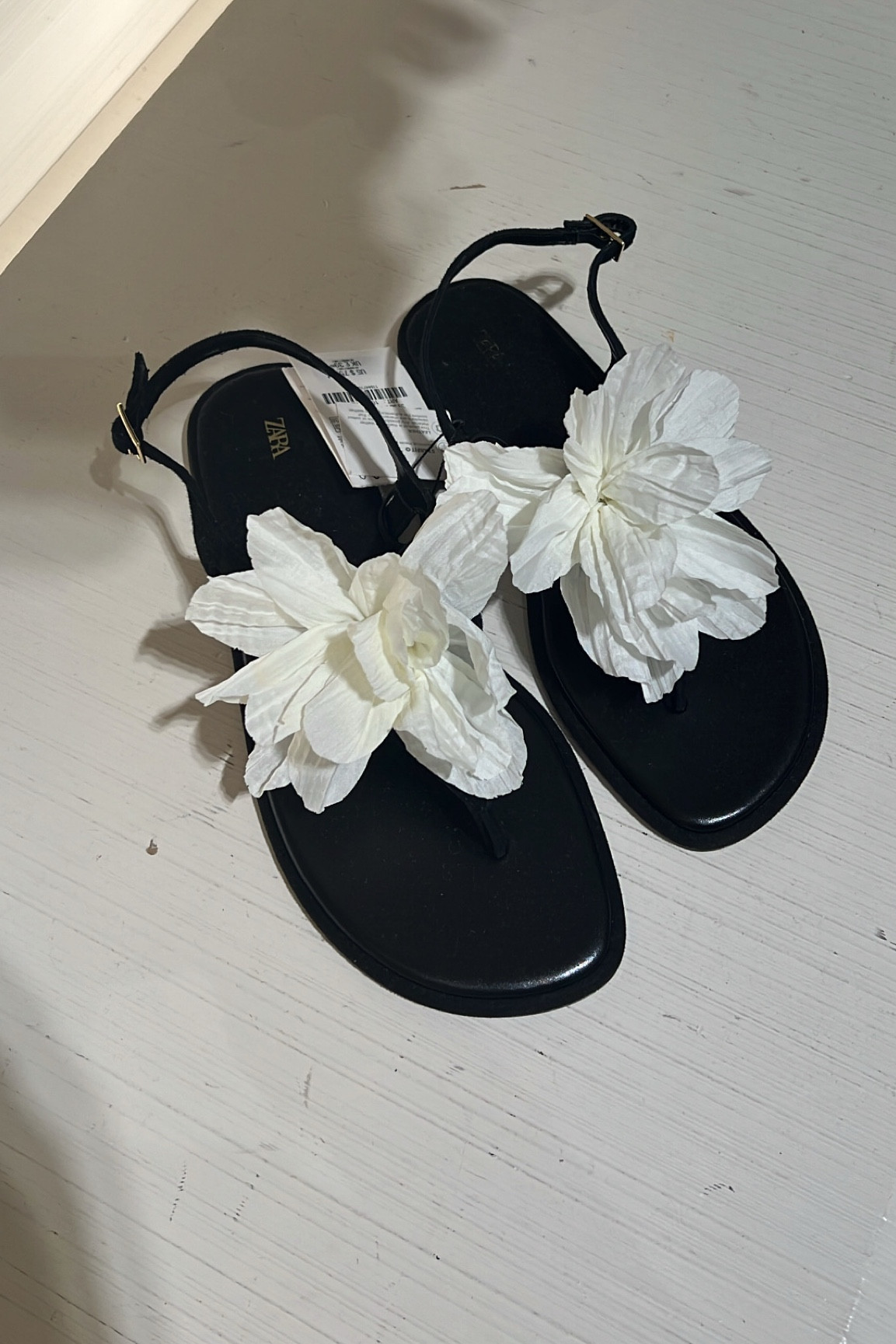 Black flat sandals with floral appliqué design! 
