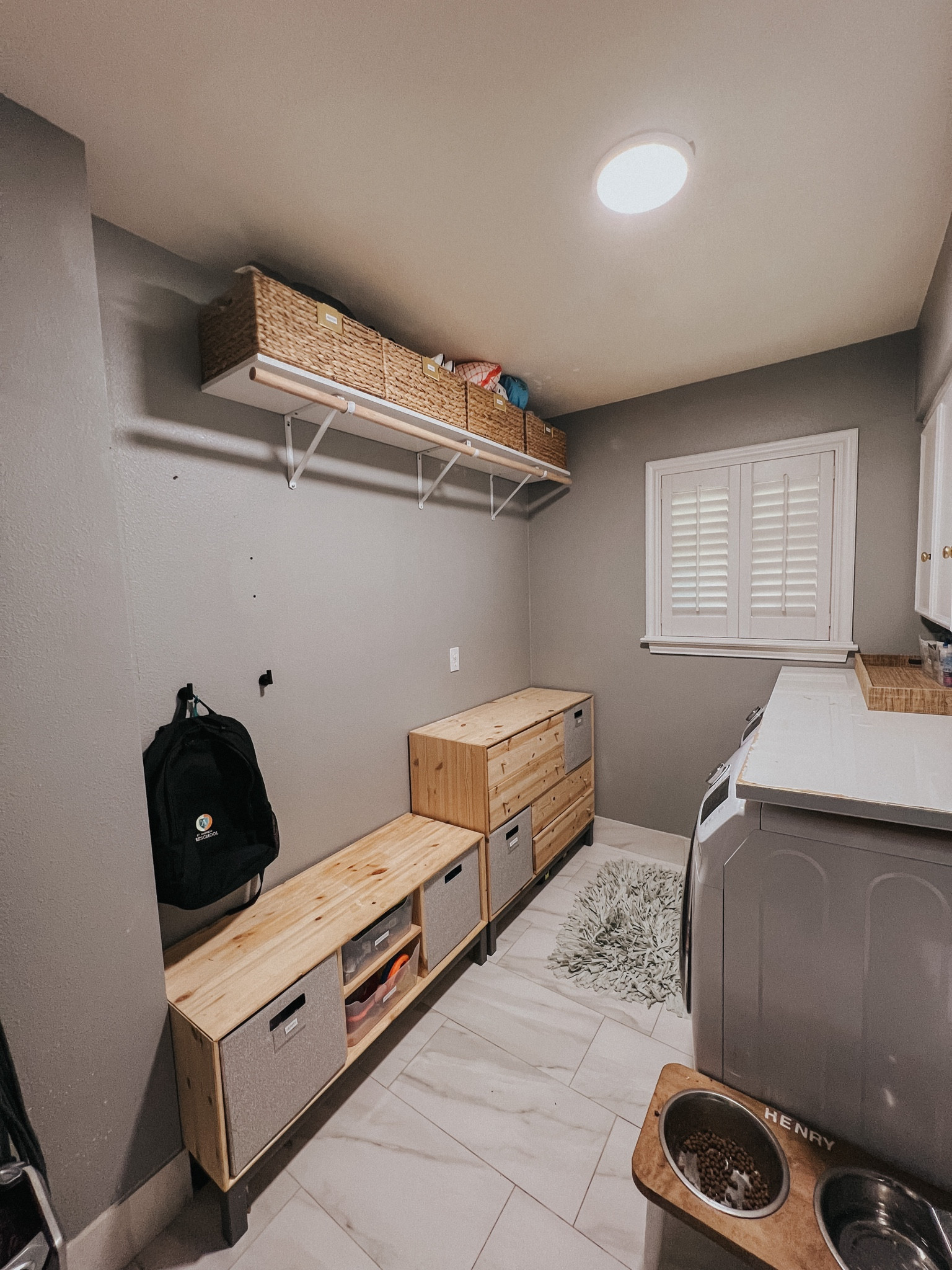 WOWZA!! I can’t even believe this is the same laundry room!! Such an amazing transformation! Tyler added a shelf above our clients hanging rack for some seasonal, summer, and travel items. Then we also added some hooks for the kids backpacks for a makeshift Mudroom!