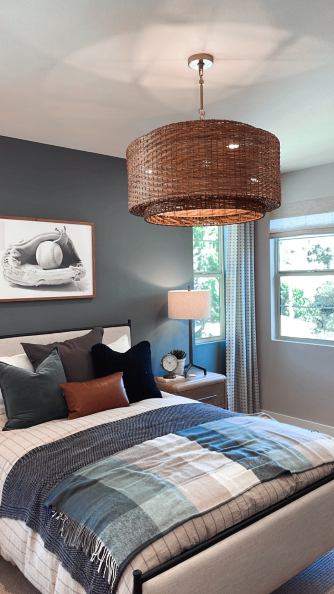 Bedroom refresh 🙌🏻 

Using the Emery bed, a woven pendant light, baseball art, and layered bedding. 

Small nightstands with sturdy metal table lamps anchor the sides of the bed. 

Upholstered bed with black metal frame. Perfect for a guest room, kids room or master bedroom. 

Use code: MENDEZMANOR for 24% off curtains, blinds and shades from Two Pages! 

#LTKHome #LTKSaleAlert