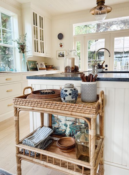 Rattan serving cart and more kitchen sources! Rattan serving cart (on sale), blue and white striped cloth napkins, woven charger, rattan round tray with handle, blue and white ginger jar, brass ceiling light, bridge faucet, similar wood flatware 

#LTKhome #LTKstyletip #LTKsalealert
