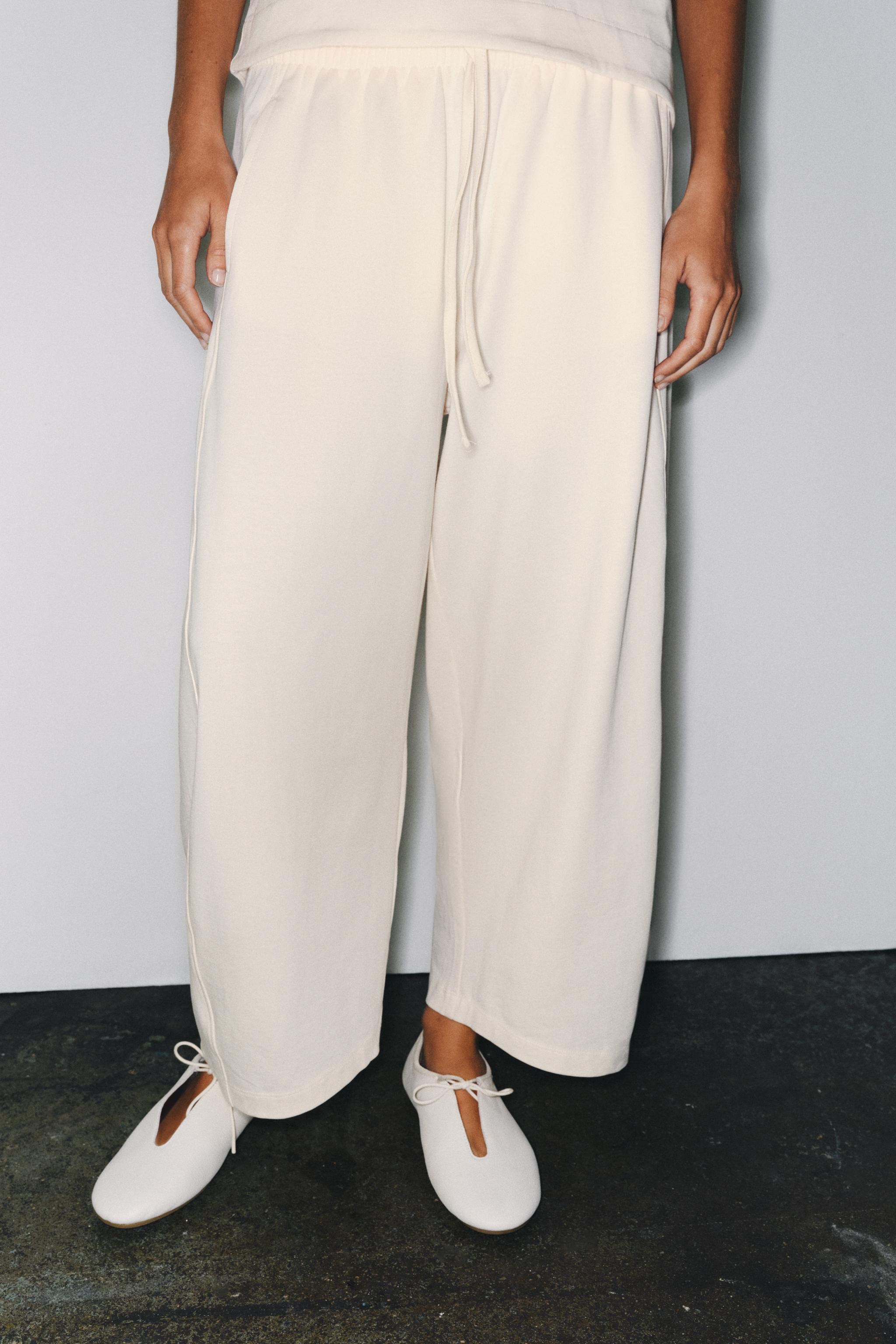 Pants made primarily with cotton yarn. Mid-rise with an adjustable elastic waistband featuring ti... | Zara US