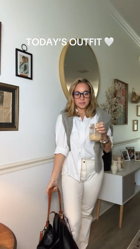 I'm wearing a crisp white button-down shirt, casually half-tucked to add dimension and ease. It's paired with high-waisted straight-leg ivory jeans. Draped over the shoulders is a classic gray knit sweater, styled as a layering piece for transitional weather and added texture. Accessories are kept minimal with black square-toe slingback flats, offering both comfort and sophistication, and a structured brown leather shoulder bag that brings subtle contrast to the neutral palette

#LTKOver40 #LTKFindsUnder50 #LTKSeasonal