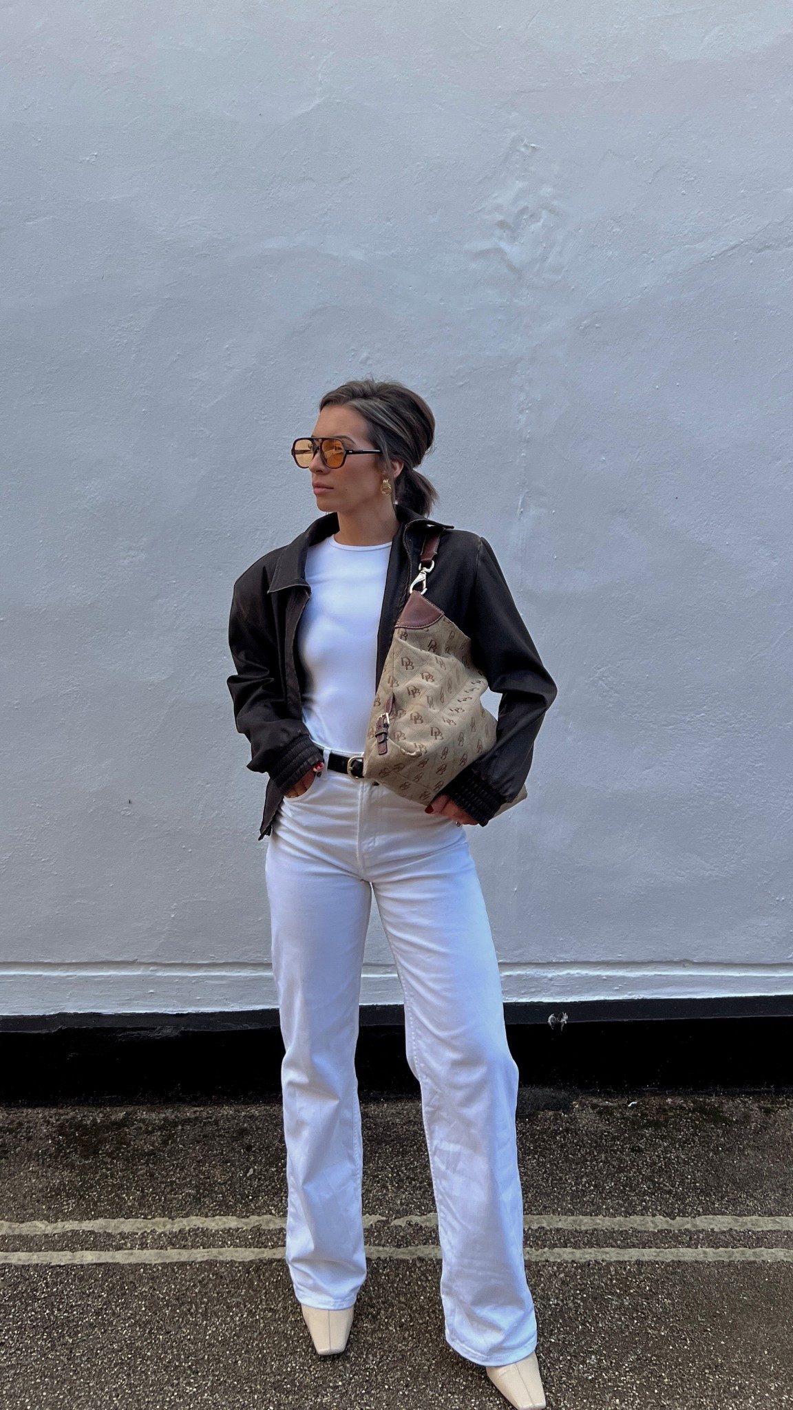 All white outfit with chocolate brown accents. White high waisted jeans. White long sleeve microfiber lululemon inspired tee. Chocolate brown leather jacket. Light lens glasses. Yellow lens glasses. Slouchy oversized tote bag. Spring transitional outfit. European style. Outfit inspo. Outfit ideas. Style ideas. 

#LTKItBag #LTKFindsUnder100