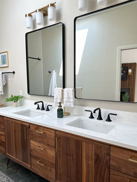 Mid-century modern style primary bathroom with extra large black metal mirrors, matte black faucets, walnut vanity, and green accents. 

Walnut vanity | matte black faucet | matte black fixtures | brass vanity light | large mirror | primary bathroom | master bathroom | green rug | green runner



#LTKhome