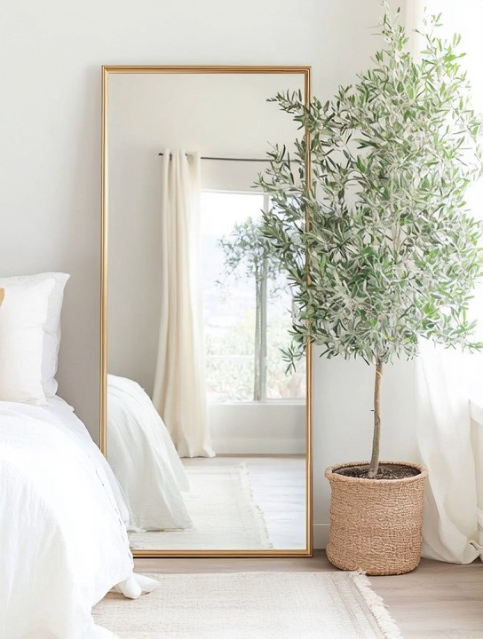 A bedroom refresh doesn’t always require a full redesign. Sometimes the most powerful upgrades are the simplest ones.

One of the easiest ways to transition from a minimalist bedroom to a more elegant, designer-inspired space is by adding a gold frame floor-length mirror paired with a beautiful olive tree. This combination instantly brings balance to the room — the mirror reflects light and makes the space feel larger, while the natural greenery adds warmth, texture, and life.

The gold frame introduces a subtle touch of luxury without overwhelming the minimalist aesthetic. Meanwhile, the olive tree softens the space and creates that effortless nature-meets-elegance look designers love.

Place this duo in an empty corner, beside the bed, or near a window and you instantly create a calm, elevated focal point.

A thoughtful bedroom refresh like this proves that sometimes all it takes is one mirror, one plant, and a little intention to completely transform the feel of a space.

#BedroomRefresh
#BedroomDecor
#MinimalistBedroom
#HomeDecorIdeas
#BedroomInspiration
#InteriorStyling 

 #LTKHome