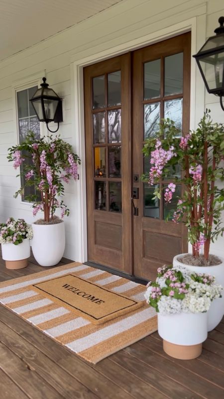 Spring Front Porch!! Loving these wisteria trees! Use BRUNOANDLIBBY for 30% off at nearly natural! Jute rug is 4x6. Front porch and front door decor large white planter trending viral home decor pottery barn dupe look a like look for less artificial faux plants trees flowers florals greenery modern farmhouse southern porch lantern, outdoor light fixtures, wall sconces lighting silk faux flowers d geraniums, hydrangeas kalanchoes pink florals jute rug scatter rug welcome mat doormat, double layered

#LTKhome #LTKstyletip #LTKVideo
