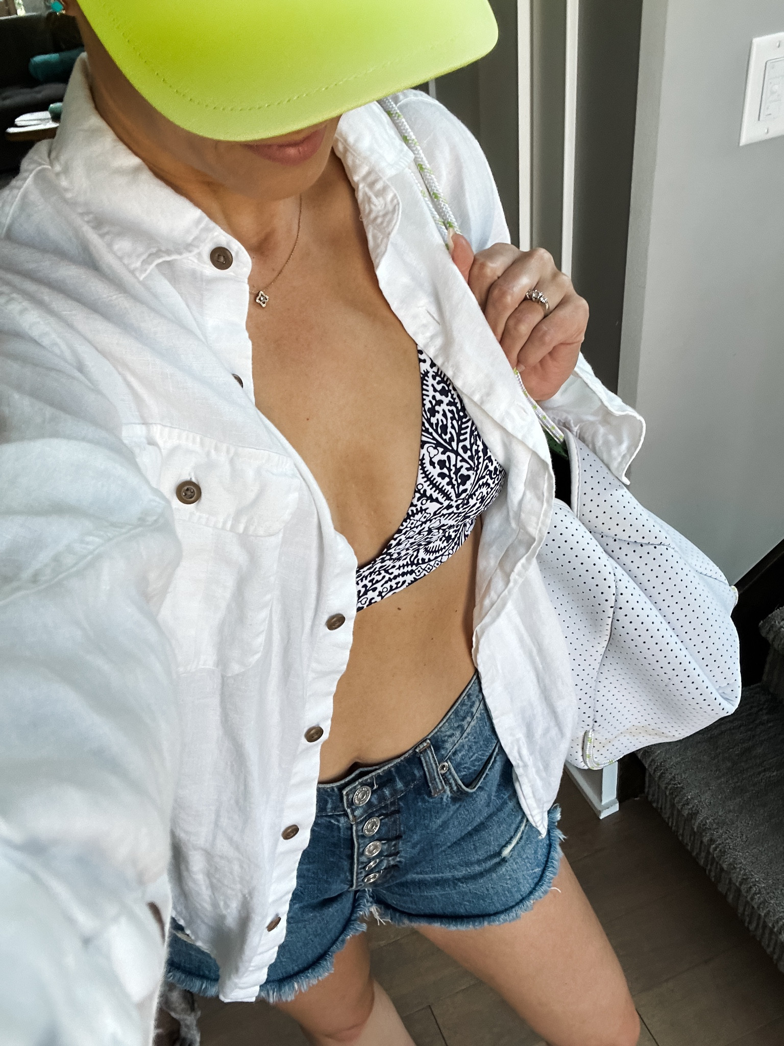 Navy and white pool day look :: white linen shirt, linen button down, oversized linen shirt, navy and white bikini, denim shorts, cutoff shorts, 7 for all mankind, neon yellow baseball hat, neon hat, summer outfit, blue bikini

#LTKswim #LTKsalealert #LTKstyletip