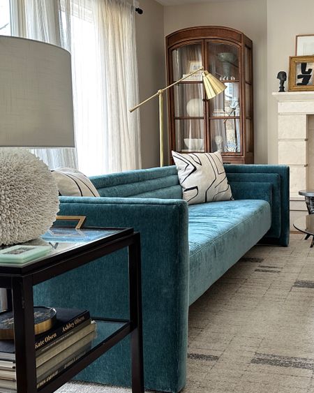 My neutral decor eclectic modern living room got a little pop of color with this teal blue sofa from Jayson Home. I love the modern design paired with the vintage arched cabinets. #interiordesign #interiors #livingroom #bluesofa #sofa #modernsofa #couch 

#LTKover40 #LTKhome
