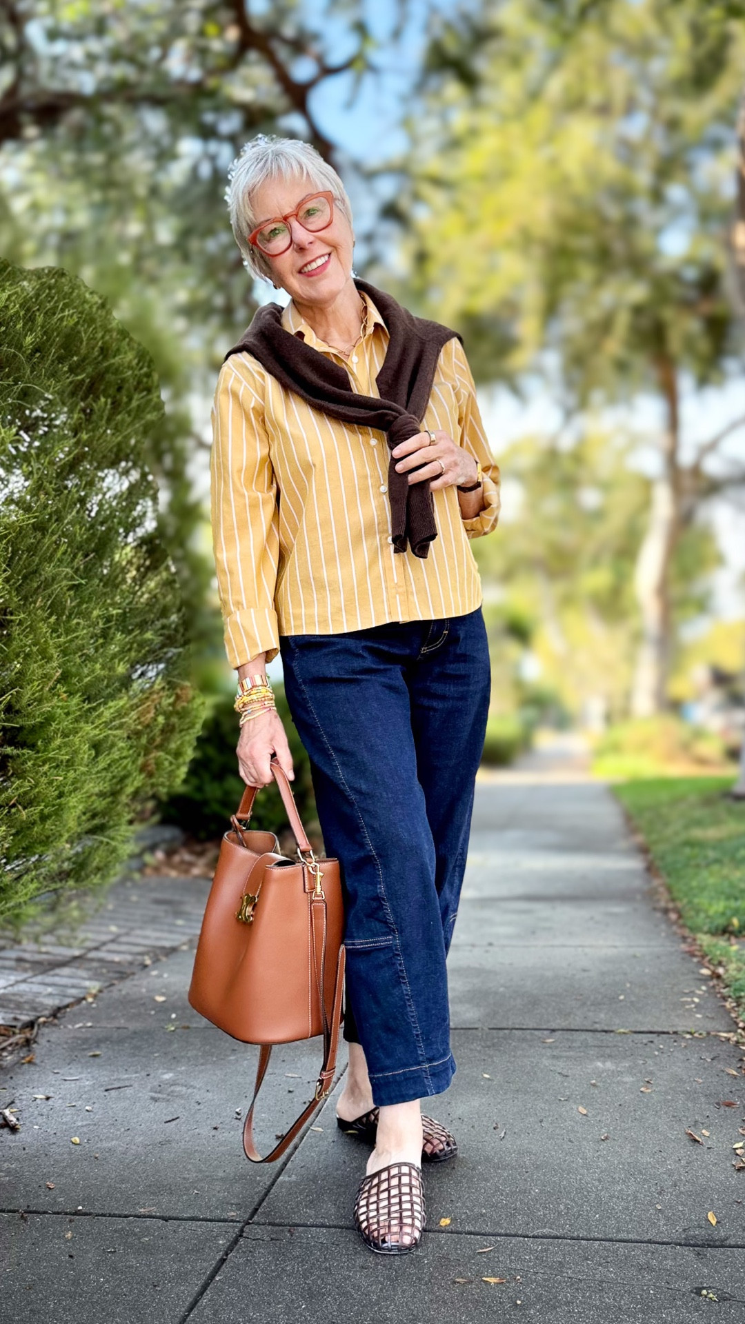 Golden tones, lightweight layers, and easy denim—fall style doesn’t always have to mean heavy knits and coats 🍂✨ This look is perfect for warm-weather autumn days: a striped button-down in a rich seasonal shade, dark denim, and a sweater draped effortlessly over the shoulders for that cozy-yet-breezy vibe. Finished with a structured bag and classic flats, it’s chic, comfortable, and transitional in the best way.


#LTKOver40 #LTKSeasonal #LTKPetite