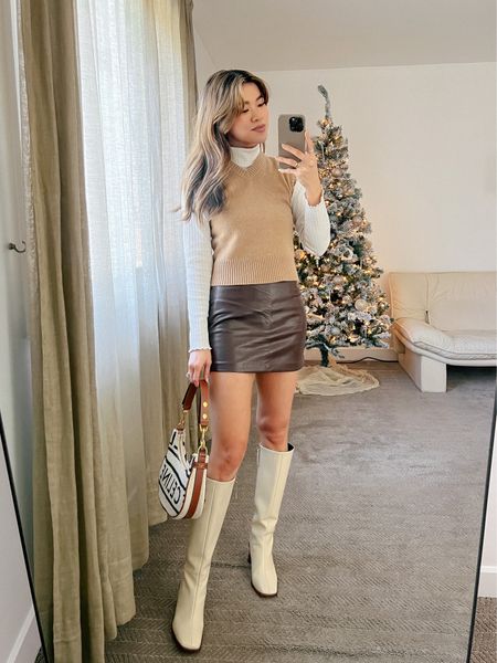 Everlane white turtleneck layered under a tan cashmere cropped sweater vest with a Abercrombie brown leather miniskirt and Alohas ivory knee-high boots!

Top: XXS/XS
Bottoms: 00/0
Shoes: 6

#winter
#winterfashion
#winterstyle
#winteroutfits
#giftsforher
#everlane
#abercrombie
#alohas

#LTKworkwear #LTKSeasonal #LTKstyletip