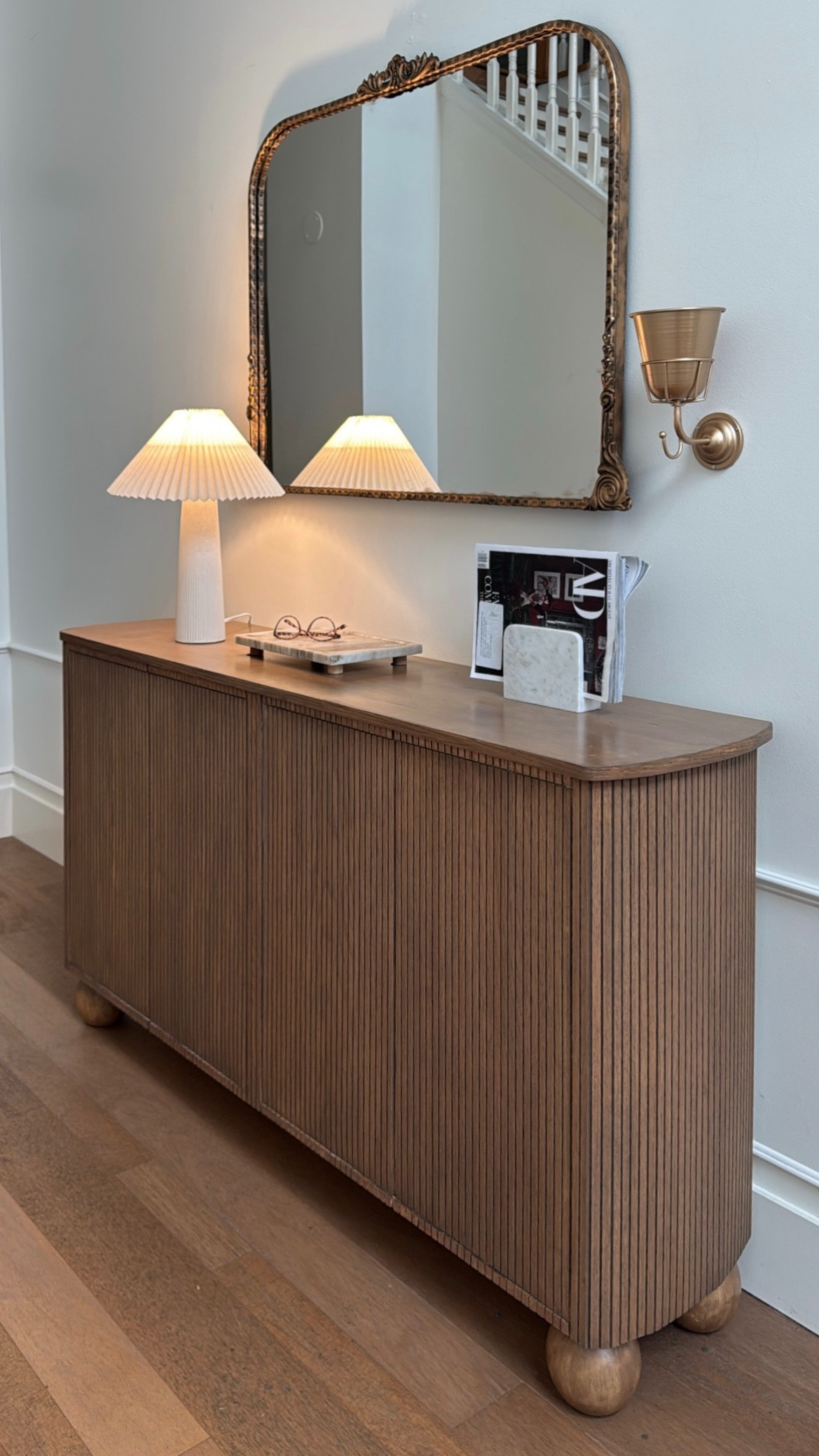 Simple entryway styling that feels warm, elevated, and intentional 🤍 a fluted wood console, soft lighting, and vintage-inspired accents make the prettiest first impression

#ltkhome #entrywaydecor #homestyling #consoledecor #neutralhome #cozyhome #interiorinspo #ltkstyle #moderntraditional #warmminimalism #homedetails #styledspaces 

 