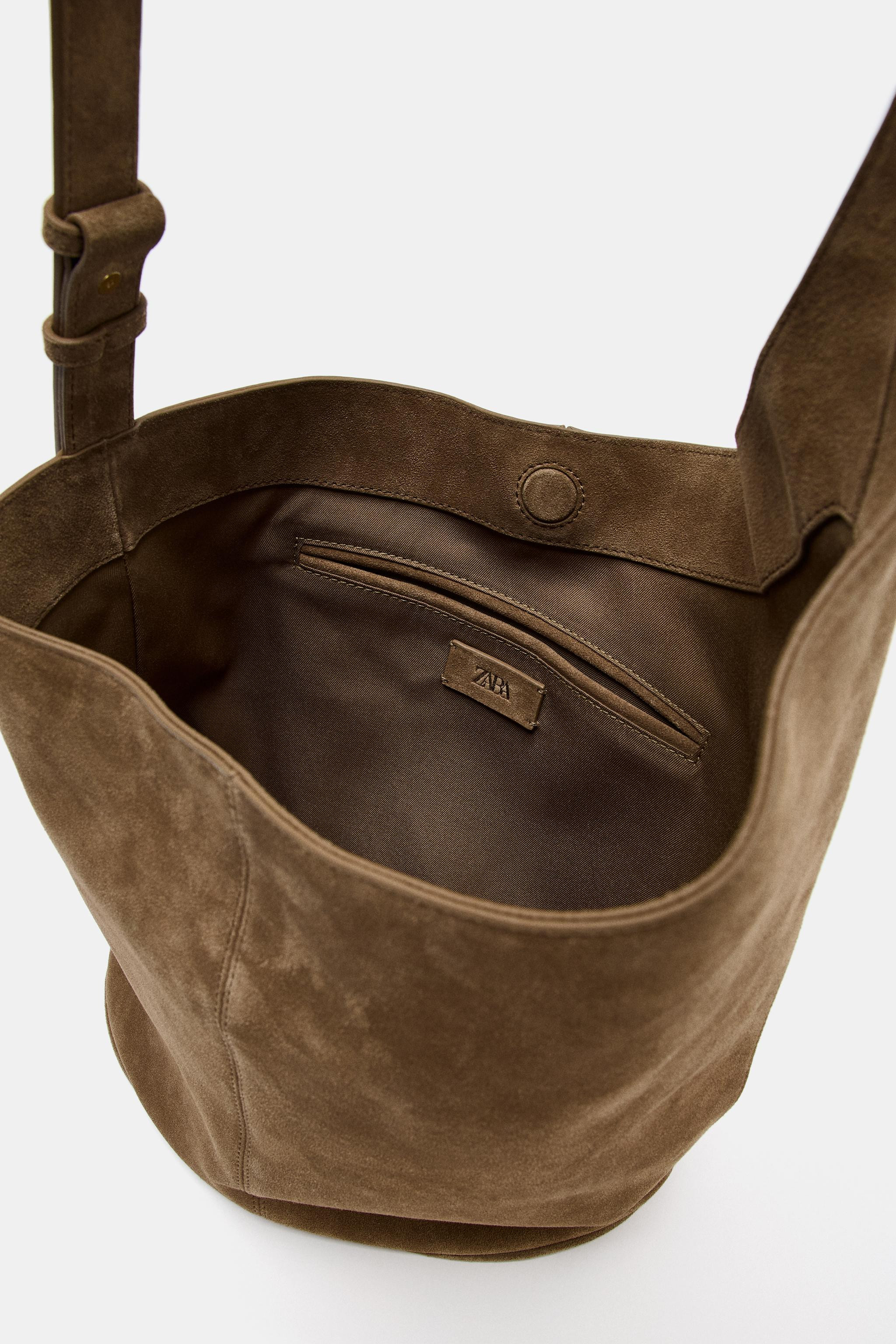 DescriptionContentsMeasurementsAsymmetric leather bucket bag. Topstitching detail on the exterior... | Zara US