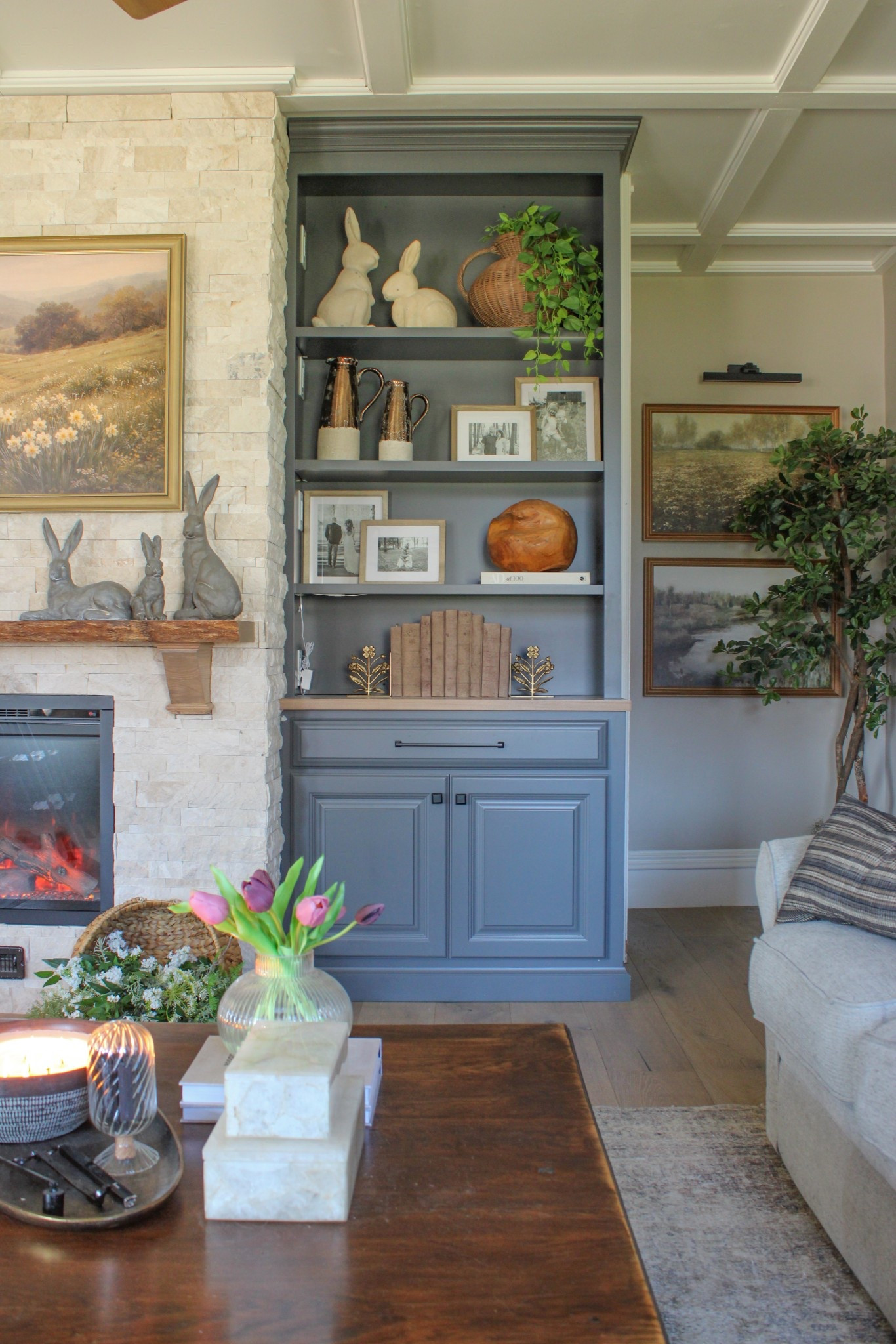 Traditional living room styling. 
Cozy, cottage farmhouse charm, vintage-inspired accents and layered details.
Textured stone fireplace surrounds to styled built-ins filled with Resin pottery barn bunnies, woven baskets, & vases, greenery, and heirloom-style frames—this space is all about timeless elegance meets seasonal decor.

If you love classic home decor, traditional interiors, and cozy spring decorating ideas, this look is for you. Save this for built-in shelf styling inspiration, neutral living room ideas, and easy ways to transition your home from winter to spring.

Collection Prints Spring Artwork | Black Olive Tree | Fluted Planter | 

#LTKHome