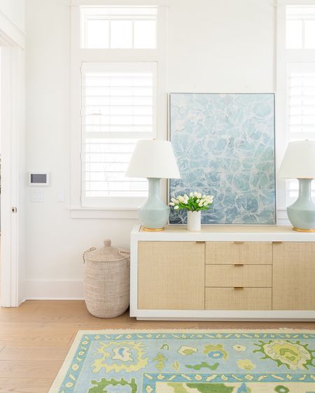 My home office decorated for spring with my linen buffet table, sparkling water art, seafoam lamps, scalloped marble vase with white tulips, woven hamper, and colorful oushak rug! See our full spring home tour here: https://lifeonvirginiastreet.com/2024-spring-home-tour/.
.
#ltkhome #ltksalealert #ltkfindsunder50 #ltkfindsunder100 #ltkseasonal coastal decor, home office decor, storage ideas 

#LTKhome #LTKSeasonal #LTKsalealert