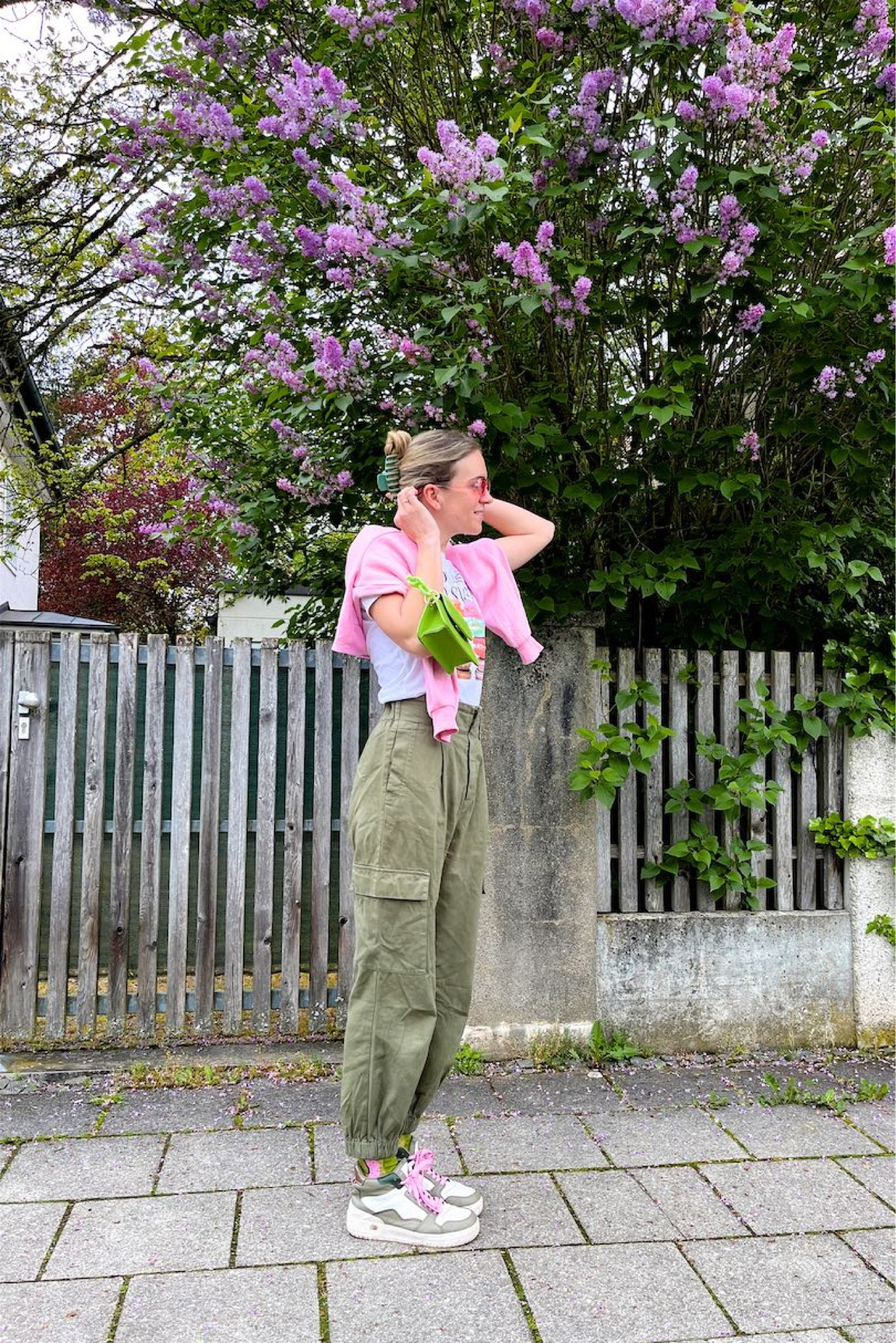 Cargo Pants. Fashion Blogger Girl by Style Blog Heartfelt Hunt. Girl with blond hair wearing cargo pants, green hair claw clip, graphic T-shirt, pink sweatshirt, pink sunglasses, neon green bag, colorful socks and green sneakers. #cargopants #greenandpink #colorfuloutfit #colorfulstyle #colorfulfashion #colorfullooks #fashionfun #cutespringoutfit #springfashion2023 #springlookbook #fitcheck #dailylooks #dailylookbook #contentcreator #microinfluencer #discoverunder20k
