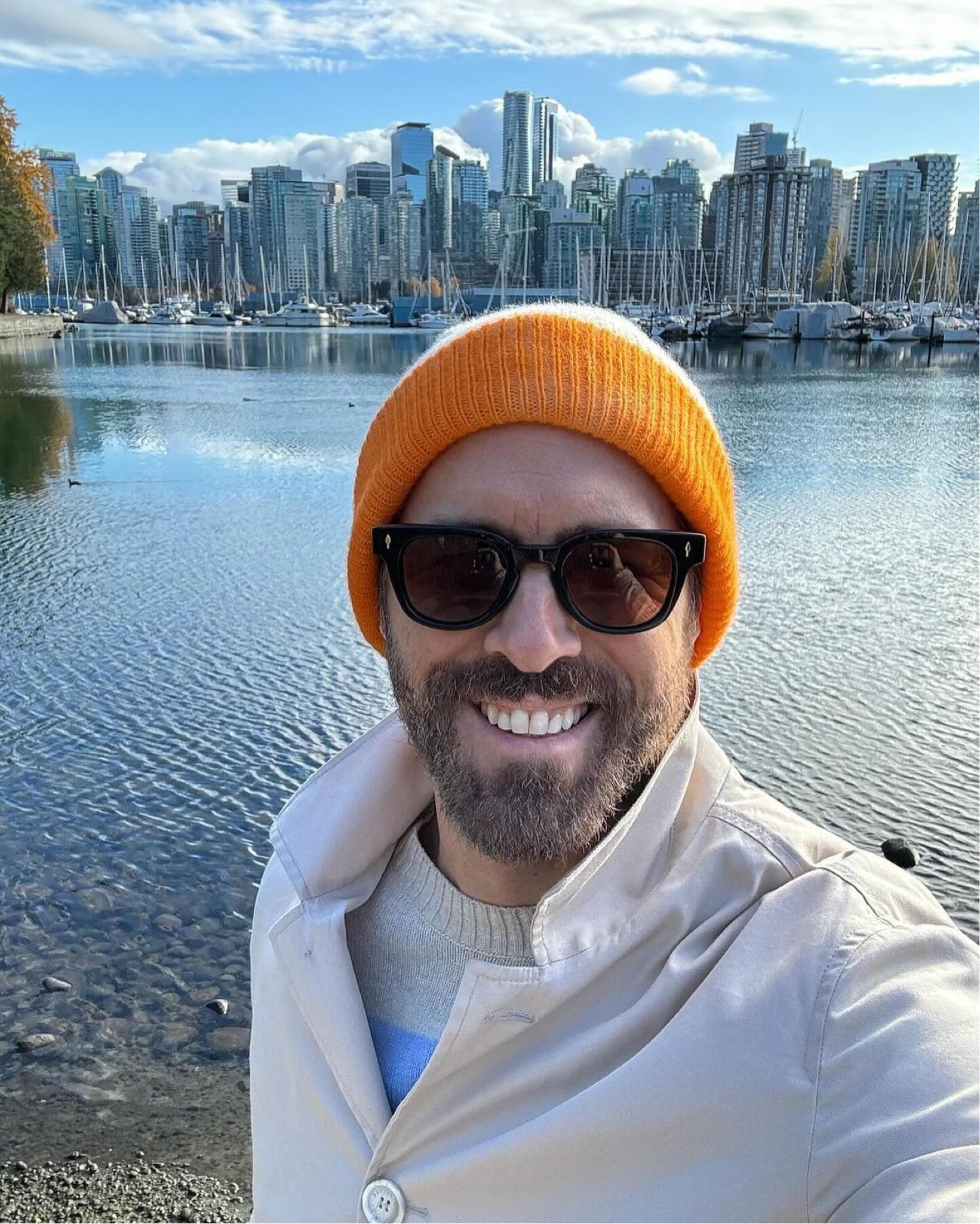 Ryan Reynolds with the view of Vancouver’s downtown behind him wearing an orange The Elder Statesman beanie, Jacques Marie Mage sunglasses, Bode sweater, and Brunello Cucinelli jacket  

#LTKMens #LTKStyleTip #LTKOver40
