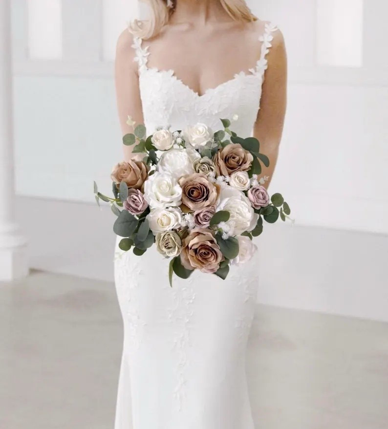 Soft, neutral tones make this taupe and champagne bridal bouquet effortlessly elegant. Designed with lifelike silk blooms in shades of beige, white, champagne, and fresh greenery, it creates a refined, romantic look that pairs beautifully with modern, rustic, or classic wedding styles. The satin ribbon-wrapped handle adds a timeless bridal finish, while coordinating pieces like boutonnieres, corsages, and cake toppers make it easy to create a cohesive floral look for your entire celebration. #LTKwedding #neutralwedding #bridalbouquet #weddingflowers #bohowedding #bridestyle #weddinginspiration #silkflowers #bridetobe #weddingdetails

#LTKWedding #LTKSeasonal #LTKHome