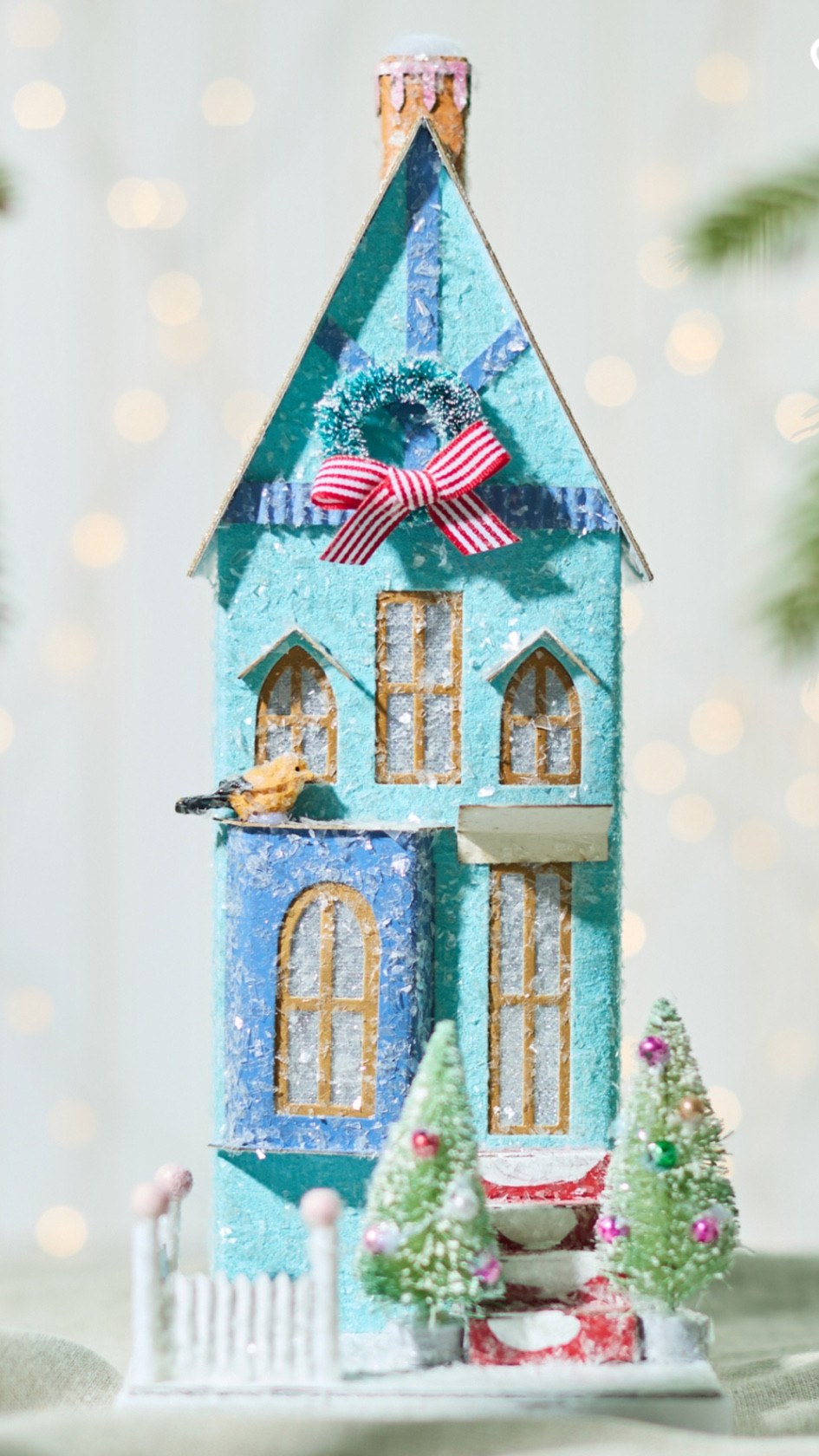 Take your holiday decor to the next level with this charming festive blue townhouse, the perfect addition to your Christmas village. From the beautifully painted white and pink picket fence to the classic Christmas wreath adorning the front roof gable, every detail captures the warmth of the season. Two decorated trees sit at the base of the stairs, creating a cozy, inviting atmosphere. Even the birds are drawn to its delightful charm, making this house the missing piece to complete your holiday scene.

#LTKHoliday #LTKHome #LTKSeasonal