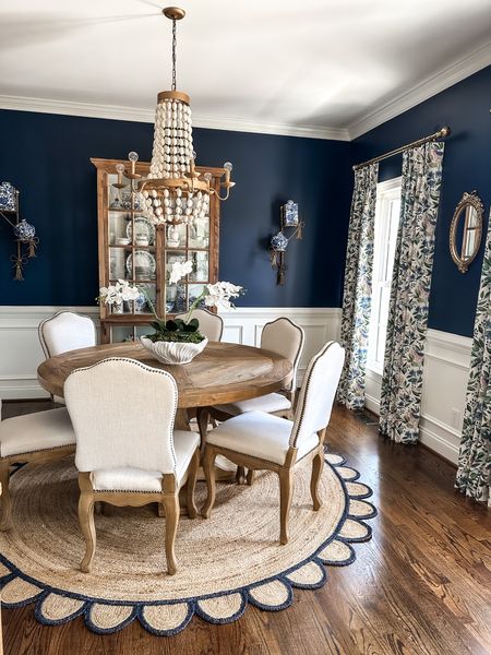 It’s been a while since I’ve shared my dining room. There are a few things in this space I am often asked about and the top question is paint color!  The room is painted Naval by Sherwin Williams and it has been this color for over 7 years now!  I have never regretted painting it this deep dark navy one single bit. In fact, I am considering having all of the white wainscoting and crown molding painted the same color for a super dramatic effect!  

All of my furniture in here came from local furniture stores, and most of the decor, like the small oval mirror and the Italian gilt bow shelves are vintage finds. I love love hunting for unique treasures for our home, and I’ve slowly added vintage pieces into this room for the past several years. Instagram tends to make people feel pressure for rooms to be instantly decorated and picture perfect, but in my opinion, design is never done and there is nothing wrong with taking your time and being patient until you find pieces that you will love for years to come!

My rug, chandelier, drapery fabric and hardware, table, and very similar chairs and china cabinet are all linked on the LTK app and my blog…the link in my profile will take you to both. Or…comment “Link” in the comments below and the details will be sent to your inbox!

#homedecor #diningroom #diningroomdecor #diningroominspo #homedecorinspo #designisneverdone #homeinteriors 

#LTKhome