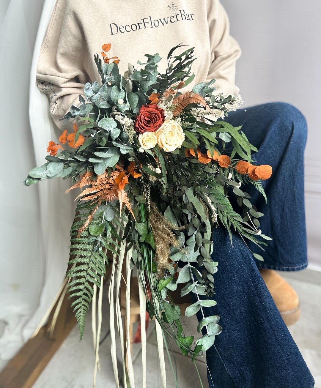 This cascading greenery bouquet features preserved eucalyptus, fern, terracotta roses, palm leaves, miskhantus, and broom bloom for a lush woodland-inspired look. The mix of warm earthy tones and textured greenery creates a naturally elegant style that’s perfect for rustic, forest, or boho weddings. Made with preserved flowers and foliage, this bouquet keeps its shape and beauty long after the celebration as a timeless keepsake. #ltkbride #ltkhome #bridalbouquet #rusticwedding #bohowedding #preservedflowers #driedflowers #woodlandwedding #weddinginspiration #bohobride

#LTKWedding #LTKHome #LTKSeasonal
