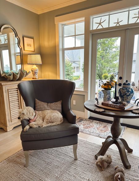 Living room corner wingback chair checkered brown pillow jute rug blue and white ginger jar pleated shade

#LTKhome #LTKstyletip #LTKSeasonal