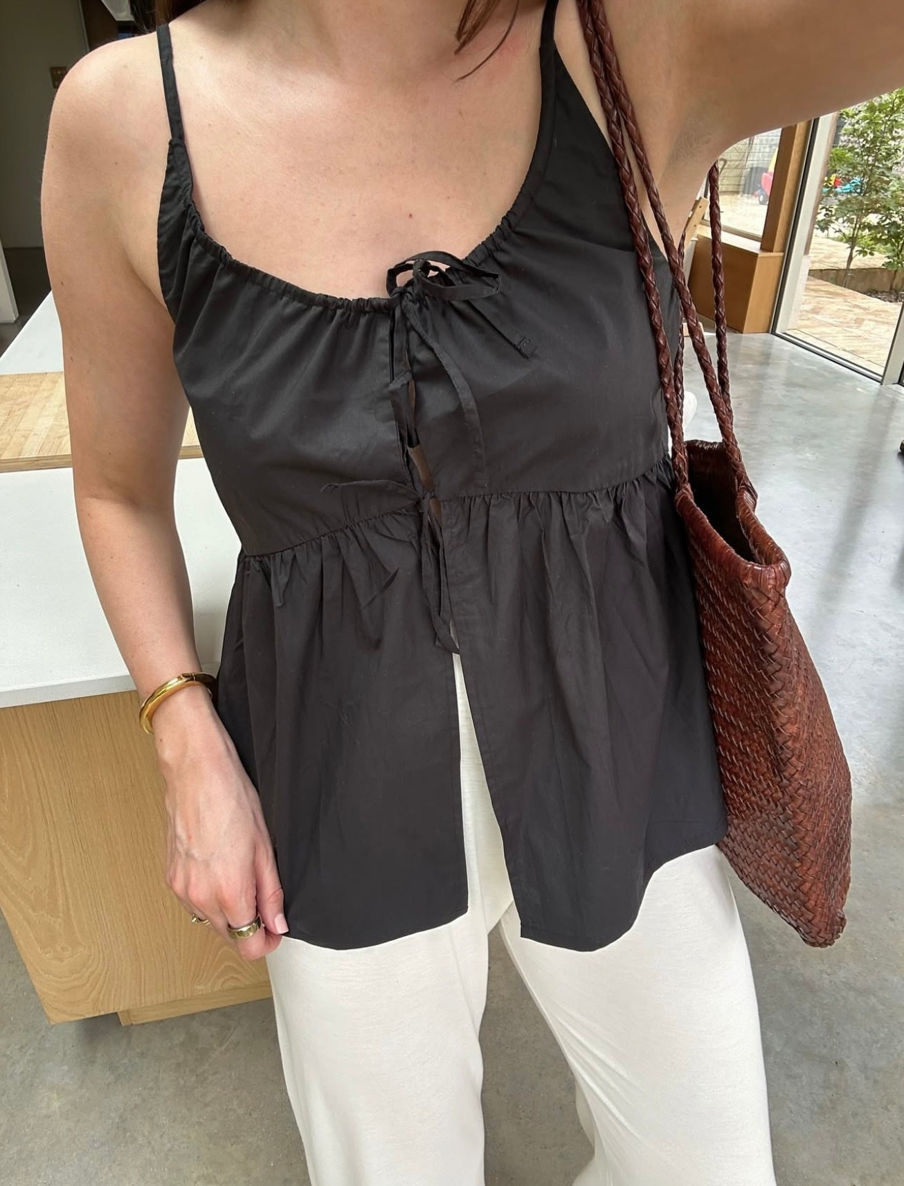 A fun tie detailed poplin top styled with loose cream trousers and a woven brown tote. Effortless yet elevated, ideal for warm summer afternoons.