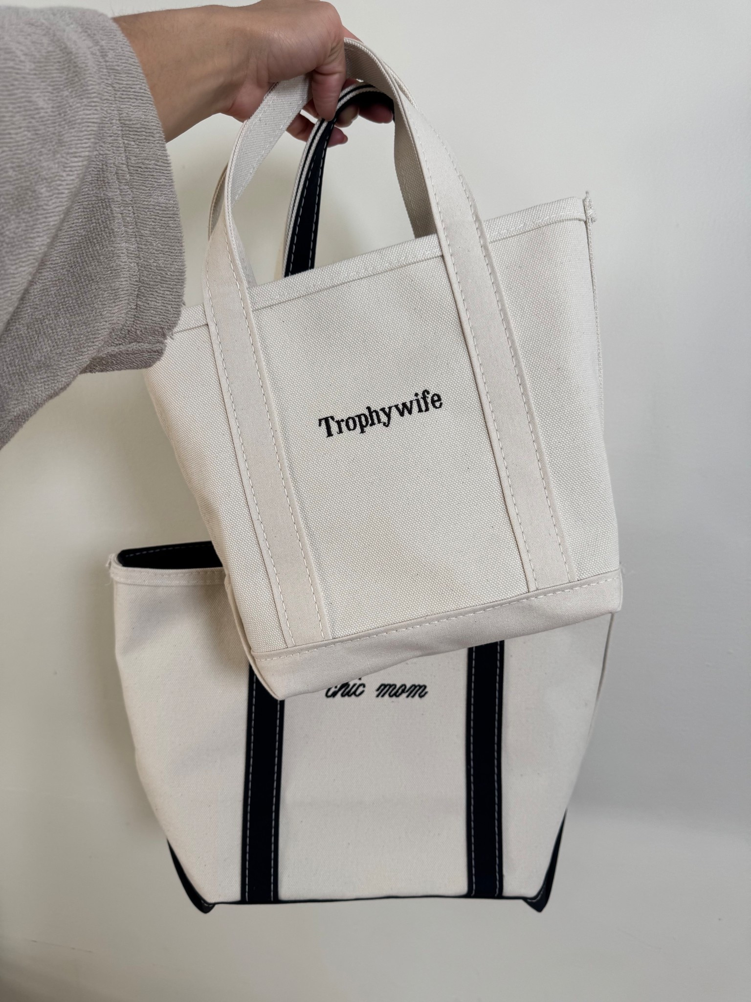 L.L. Bean Boat & Totes

Details: 
Bag 1 (chic mom)
Boat & Tote Zip Top 
Size: Med
Handles: Long  
Color: Black Trim 
Monogram: Thin Script (black)

Bag 2: Trophywife
Boat & Tote 
Size: Small
Handles: Reg
Color: Natural  
Monogram: Times Bold (dark brown)

#llbean #llbeanboatandtote #boatandtote #canvasbag