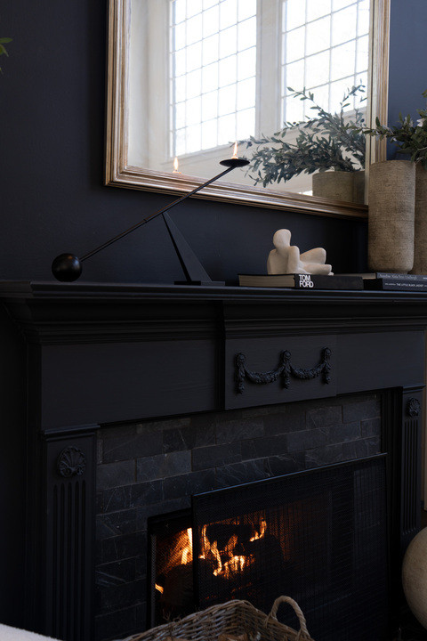 OKAY the modern candlestick on this fireplace just stole the whole show!! The sleek sculptural shape against the black mantel with the soft candle glow feels so elevated and architectural. Paired with the oversized mirror and greenery it instantly gives high end designer living room energy and I am obsessed!  

 #LTKSeasonal #LTKOver40 #LTKHome